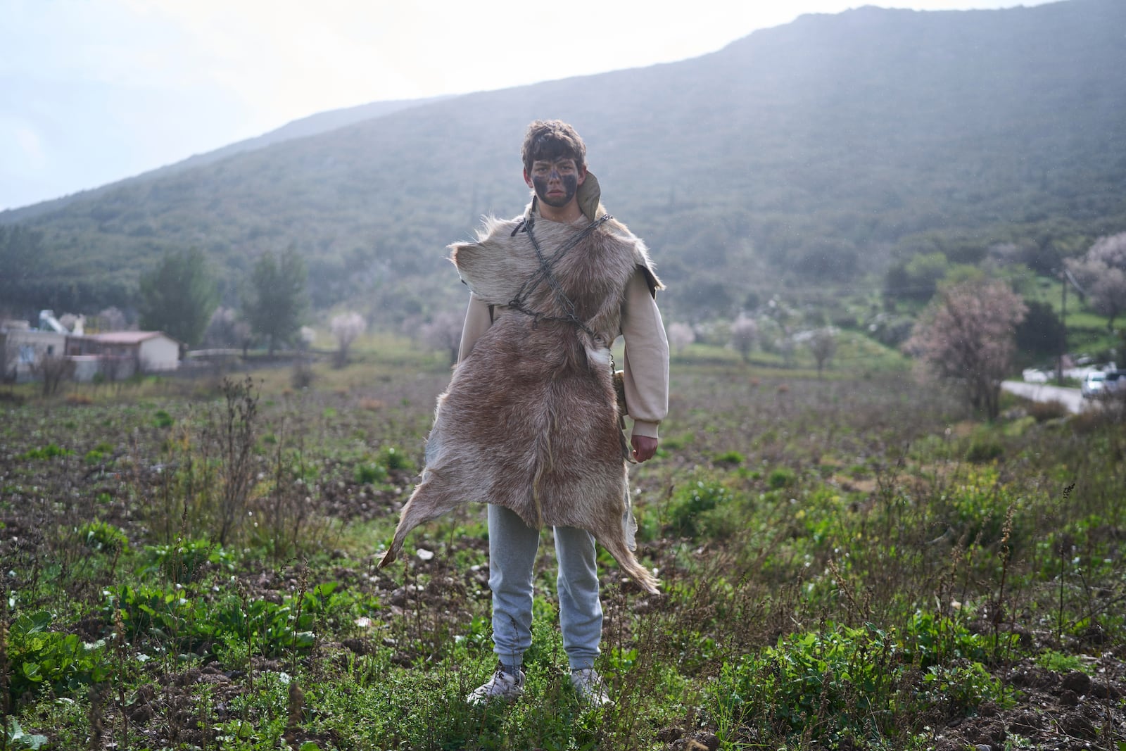 Mehmet Ahmetoglou, 17, poses for a portrait, dressed in animal skins and heavy bronze bells, as part of carnival celebrations in Distomo, a village in central Greece, on Monday, March 3, 2025. (AP Photo/Petros Giannakouris)