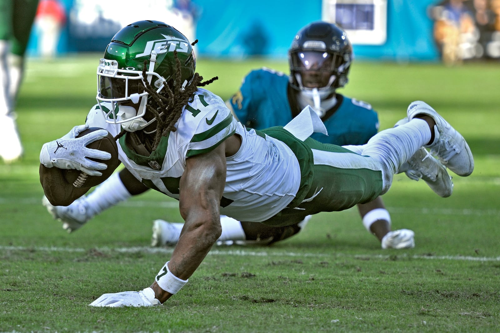 New York Jets wide receiver Davante Adams (17) dives past Jacksonville Jaguars safety Darnell Savage (6) after a catch during the second half of an NFL football game Sunday, Dec. 15, 2024, in Jacksonville, Fla. (AP Photo/Phelan M. Ebenhack)