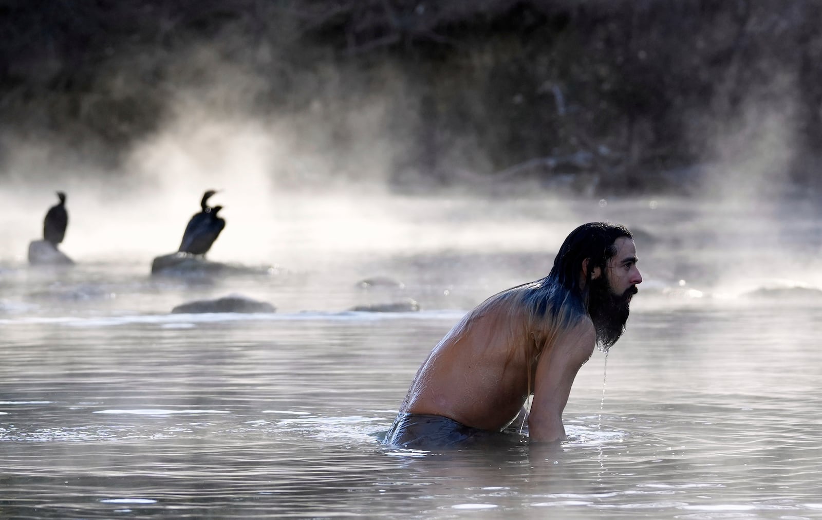 FILE - Atlus Orion takes a dip in Barton Creek in Austin, Texas, Dec. 23, 2022, as steam fog was rising from the creek. (Jay Janner/Austin American-Statesman via AP)