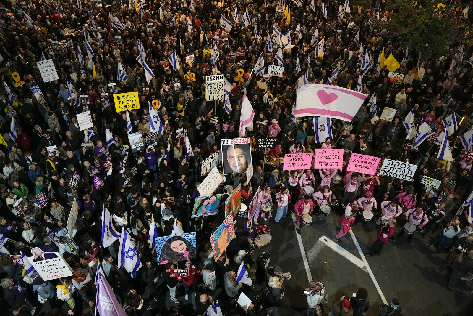 Israelis protest against Prime Minister Benjamin Netanyahu's government and call for the release of hostages held in the Gaza Strip by the Hamas militant group, in Tel Aviv, Israel, Saturday, Dec. 14, 2024. (AP Photo/Tsafrir Abayov)