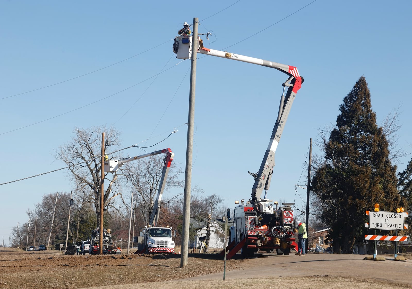 Ohio Edison crews replace utility poles along Fletcher Pike Thursday. BILL LACKEY/STAFF