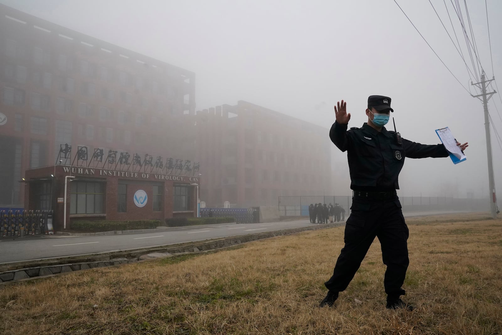 FILE - A security person moves journalists away from the Wuhan Institute of Virology after a World Health Organization team arrived for a field visit in Wuhan in China's Hubei province, Feb. 3, 2021. (AP Photo/Ng Han Guan, File)