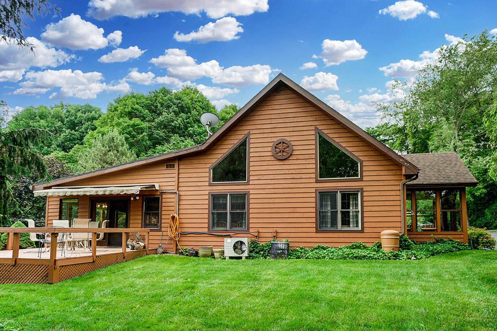 The rear of the property can be seen from most rooms in the home and features a brick patio between the home and detached garage. A large deck includes an electric awning. The family room addition has a wall of windows overlooking the back of the property. CONTRIBUTED PHOTO