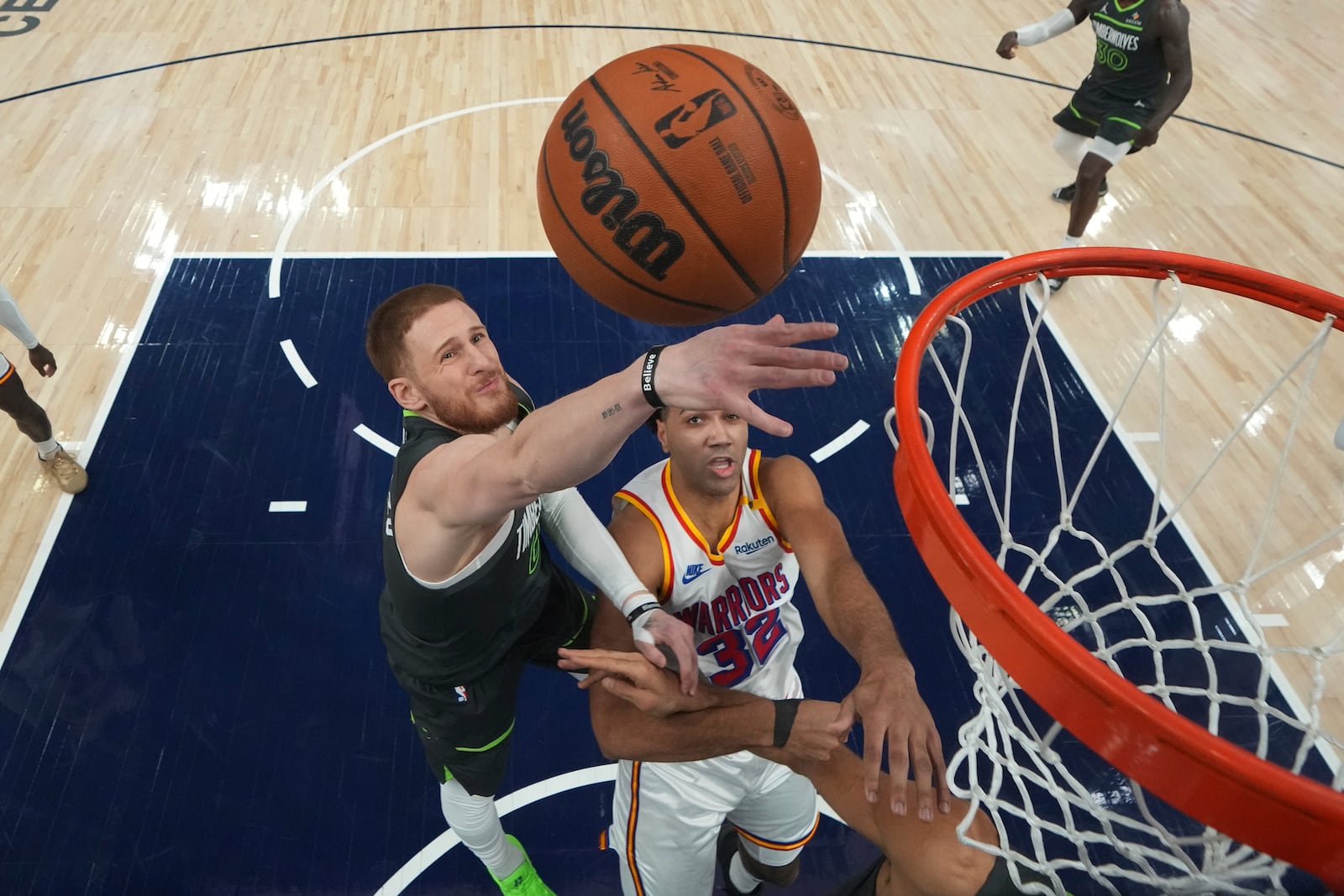 Minnesota Timberwolves guard Donte DiVincenzo (0), left, and Golden State Warriors forward Trayce Jackson-Davis (32) battle for a rebound during the first half of an NBA basketball game, Wednesday, Jan. 15, 2025, in Minneapolis. (AP Photo/Abbie Parr)