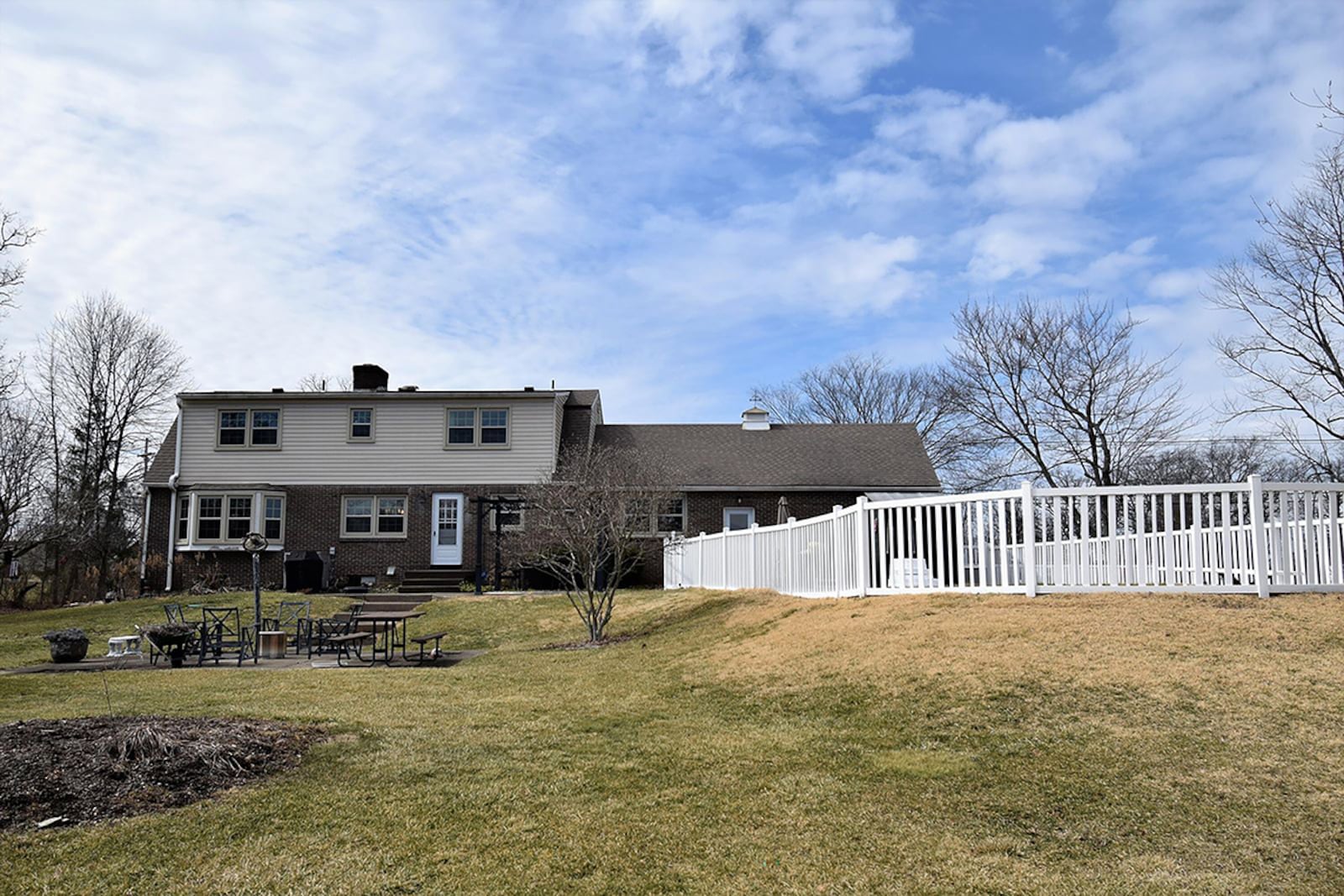 The rear of the home features a fully fenced, in-ground pool with diving board, hot tub, a large, unfenced yard with yard barn, flagpole, additional patio and extensive landscaping. CONTRIBUTED PHOTO