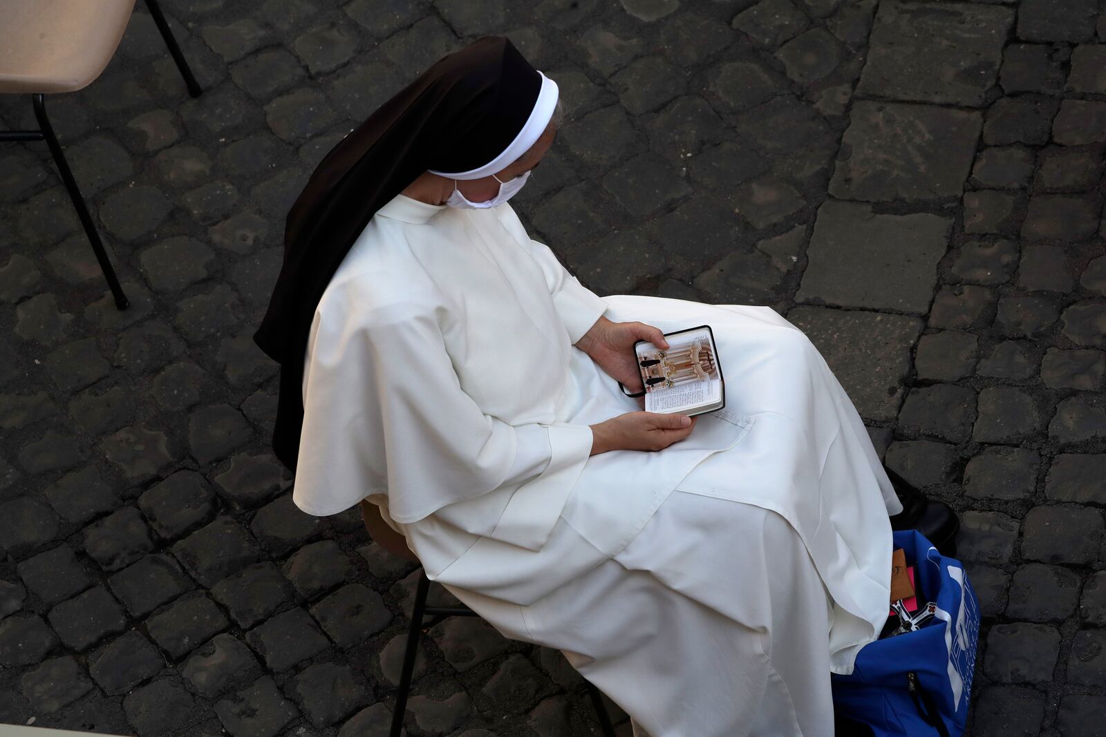 A nun waits for Pope Francis weekly general audience in San Damaso courtyard at the Vatican, Wednesday, Sept. 9, 2020. (AP Photo/Andrew Medichini)