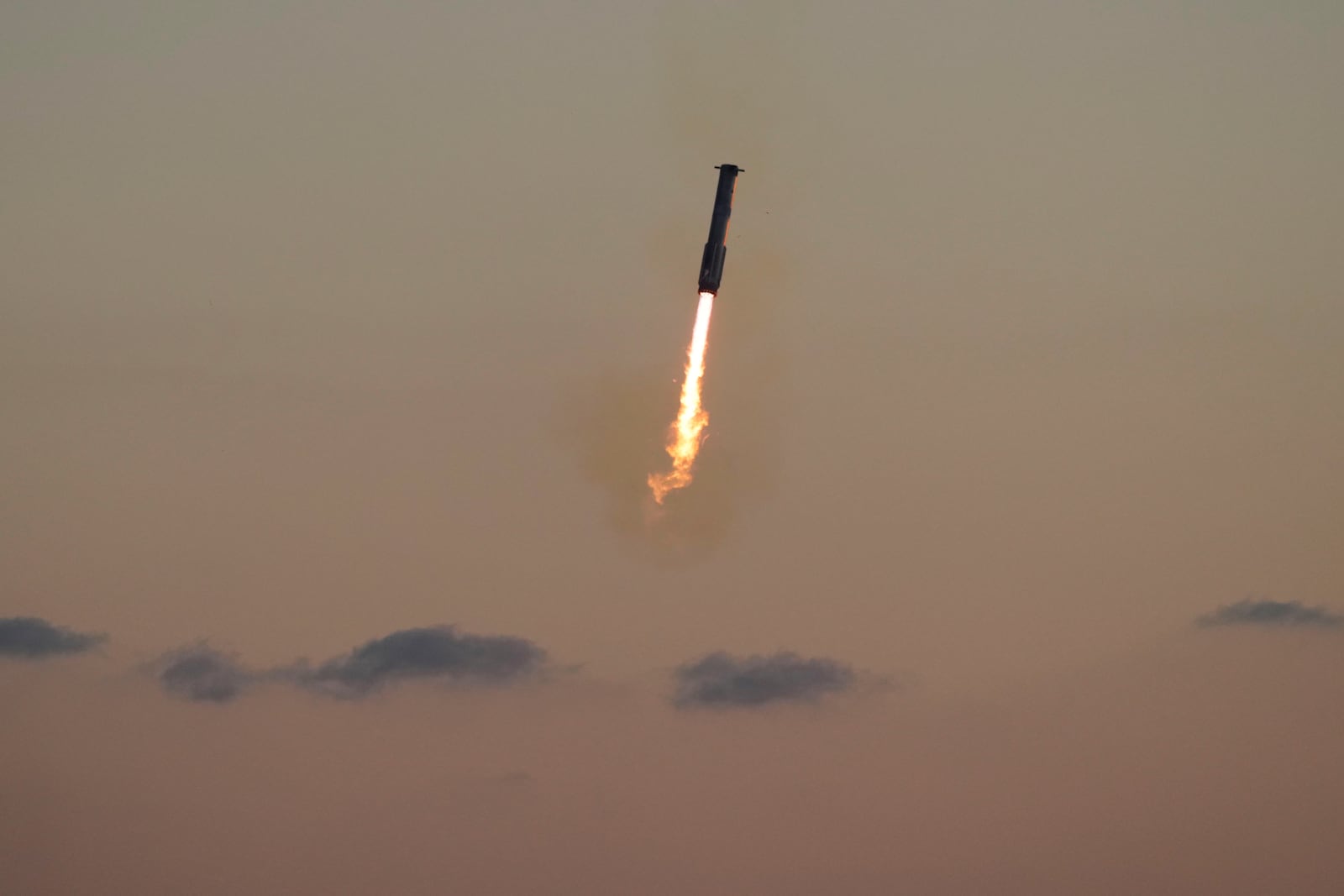 SpaceX's mega rocket booster returns to the launch pad to be captured during a test flight Sunday, Oct. 13, 2024, in Boca Chica,, Texas. (AP Photo/Eric Gay)