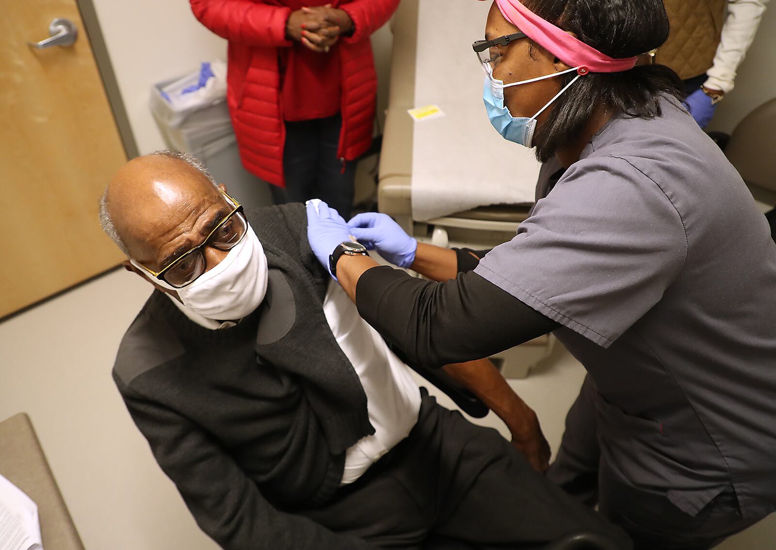 Former Springfield Police Chief Roger Evans gets a COVID-19 vaccine injection from Sherita Bloxom, a nurse at the Rocking Horse Center Thursday.. The Rocking Horse Center started giving out the vaccine to seniors over 80 Thursday. BILL LACKEY/STAFF