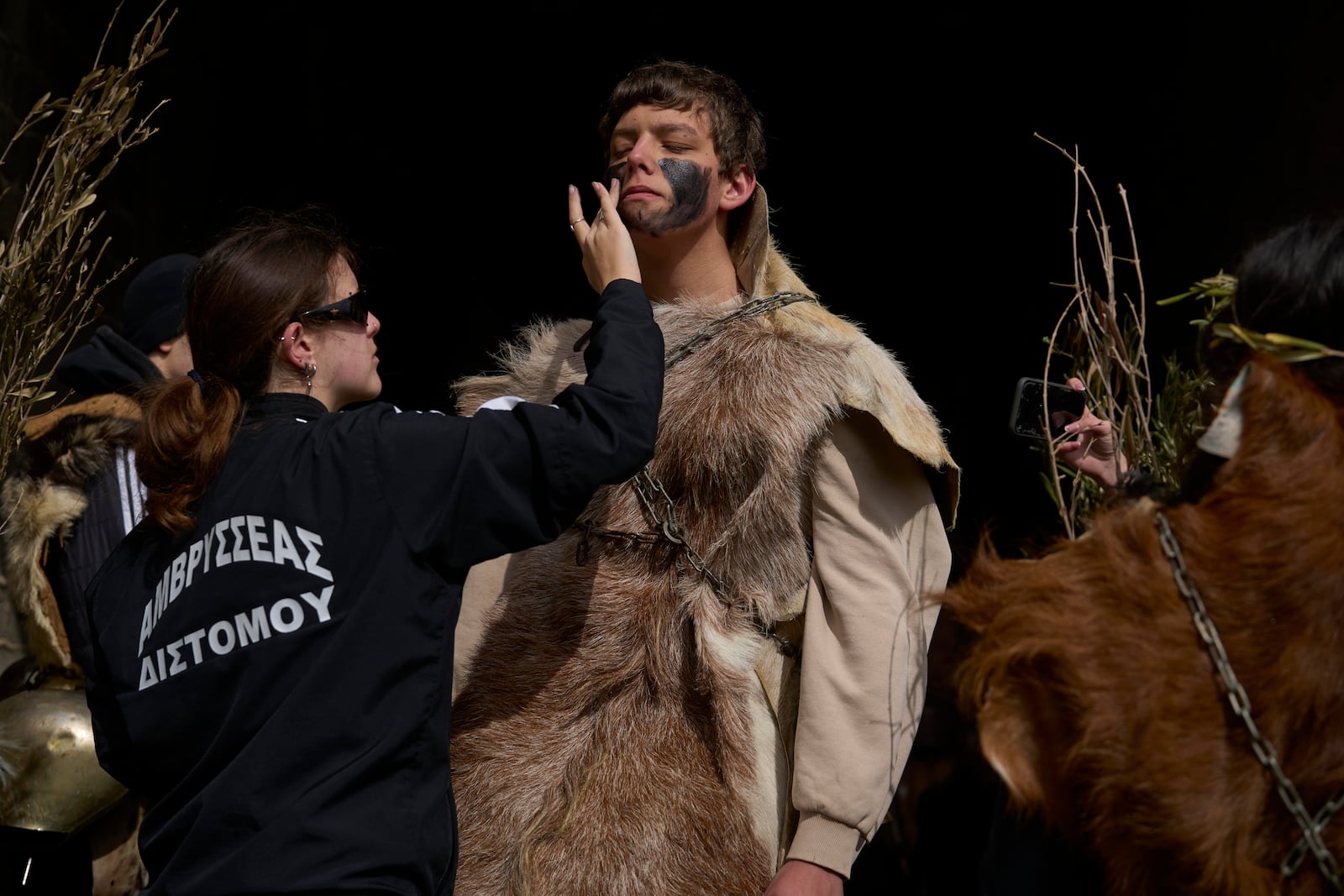 Revellers dressed in animal skins and heavy bronze bells, prepare to take part in carnival celebrations in Distomo, a village in central Greece, on Monday, March 3, 2025. (AP Photo/Petros Giannakouris)