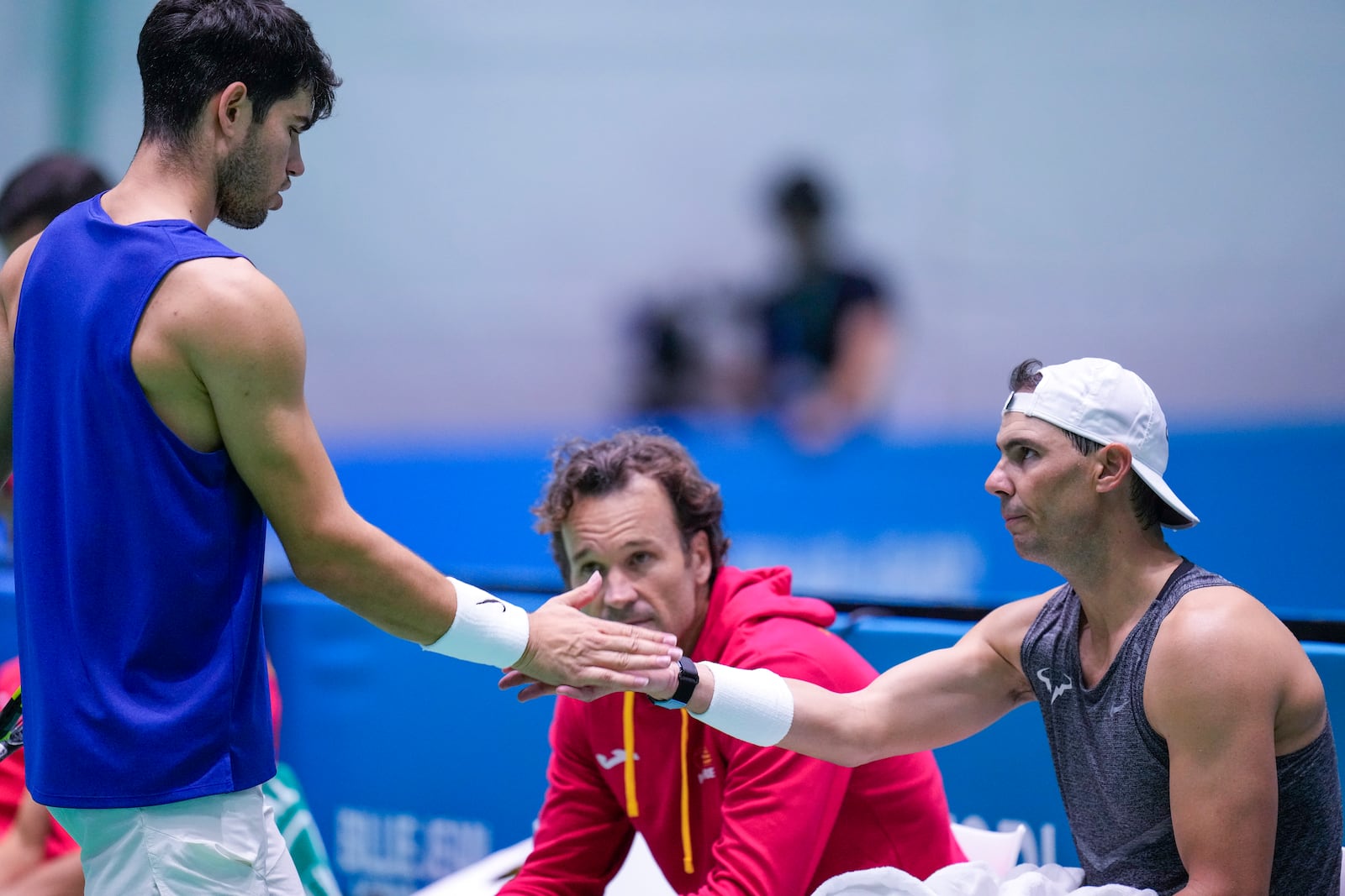 Spain's Carlos Alcaraz, left, shakes hands with Rafael Nadal during a training session at the Martin Carpena Sports Hall, in Malaga, southern Spain, on Sunday, Nov. 17, 2024. (AP Photo/Manu Fernandez)