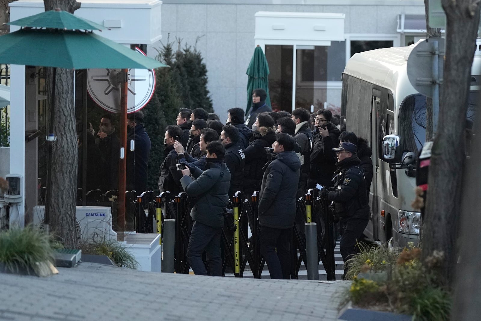 Police officers arrive at the gate of the presidential residence as supporters of impeached South Korean President Yoon Suk Yeol stage a rally to oppose a court having issued a warrant to detain Yoon, in Seoul, South Korea, Friday, Jan. 3, 2025. (AP Photo/Lee Jin-man)