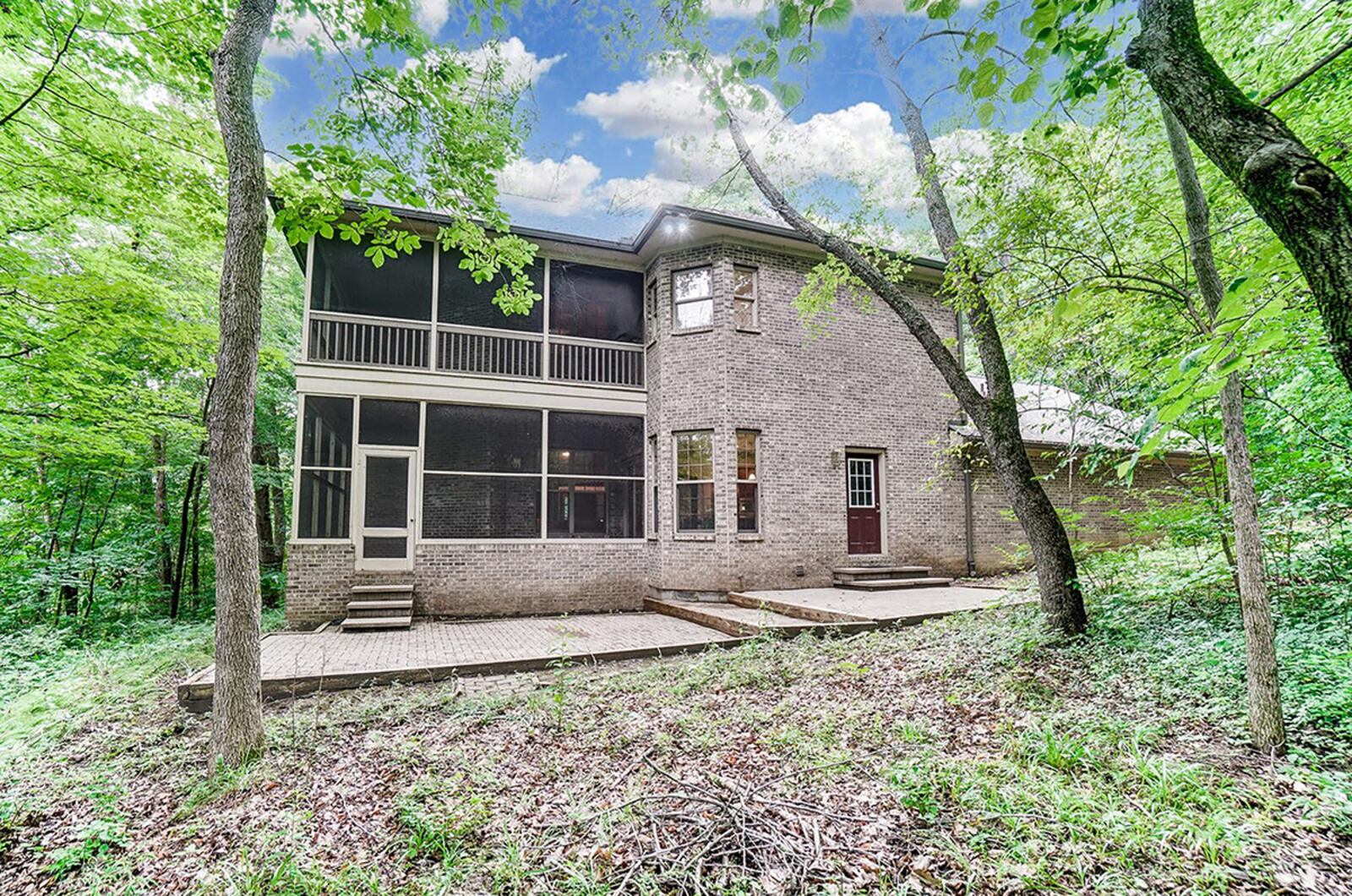 The back of the home features 2 wrap-around, screened porches, double connected brick patios and pathways to the front. There is also outdoor lighting and wooded views. CONTRIBUTED PHOTO