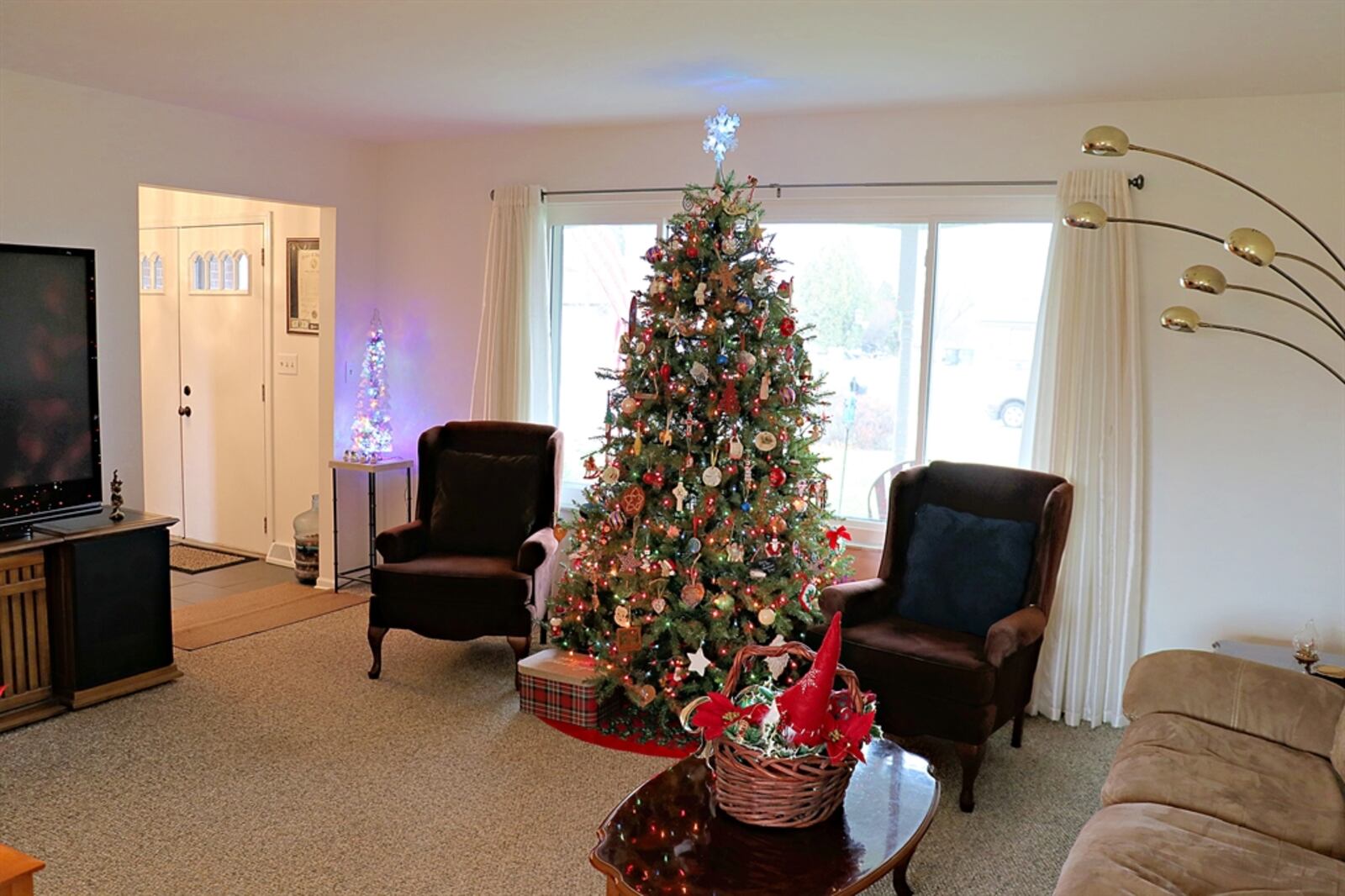 The formal living room features a picture window and transitions into the formal dining room.