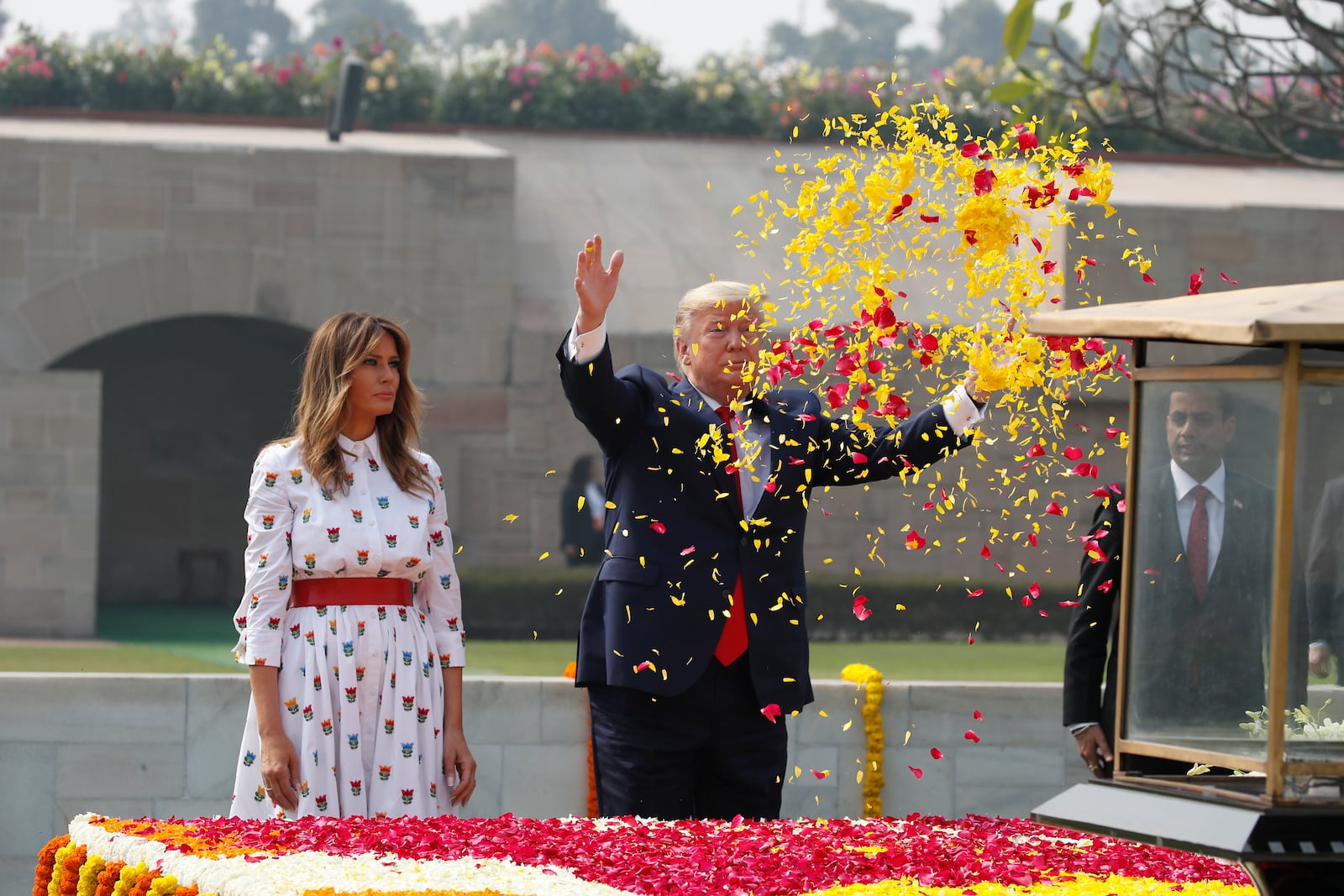 U.S. President Donald Trump offers floral respects, with first lady Melania Trump standing beside him, at Raj Ghat, the memorial for Mahatma Gandhi, in New Delhi, India, Feb. 25, 2020. (AP Photo/Alex Brandon, File)