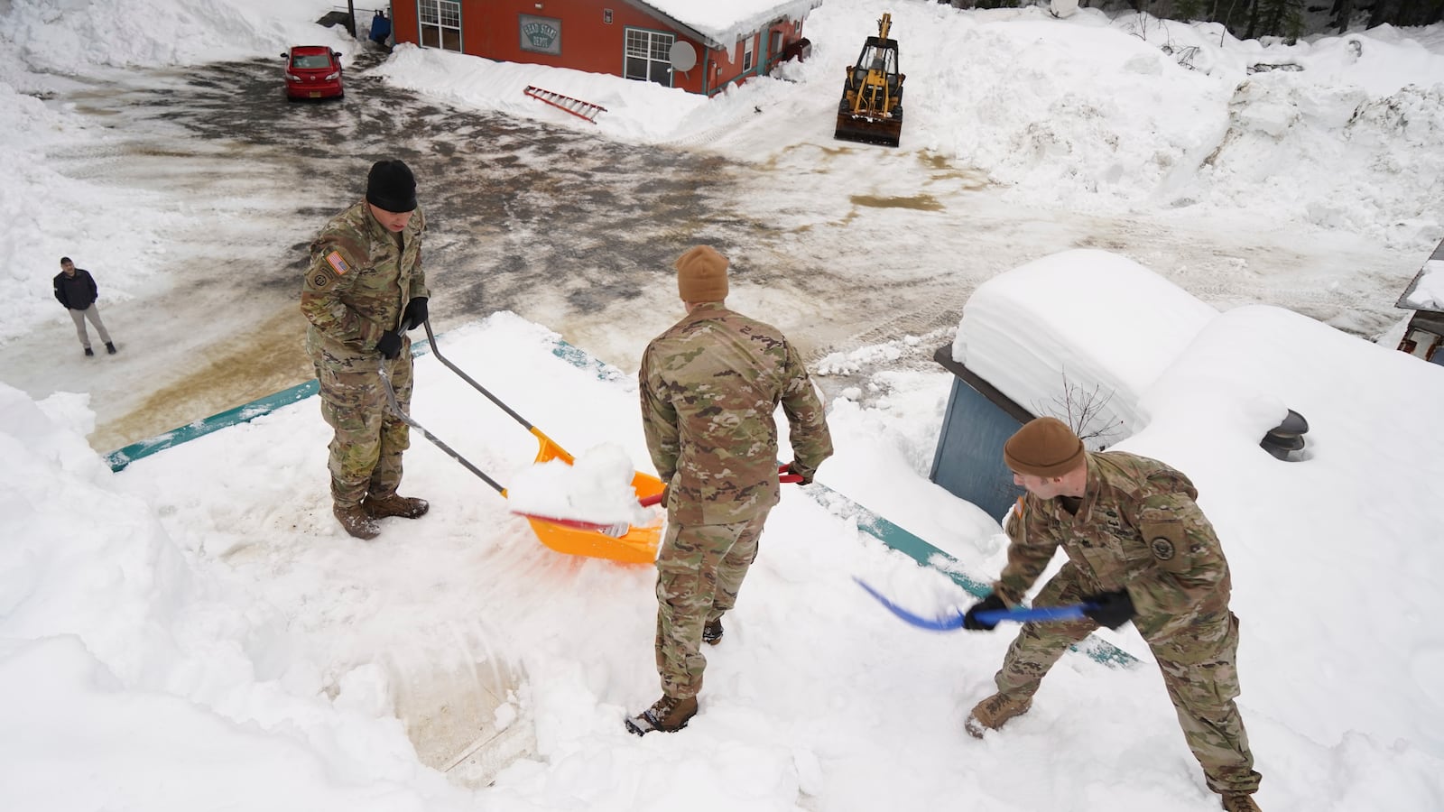 Alaska National Guard soldiers and airmen shovel the roof of a building in Yakutat, Alaska. (Photo by Dana Rosso, U.S. Army National Guard via AP)