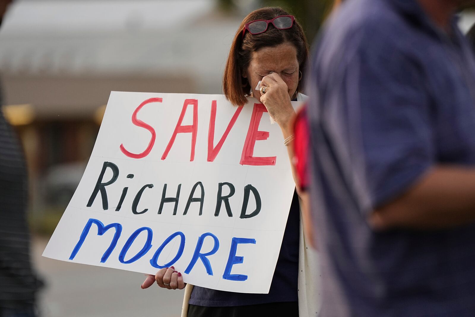 A protestor weeps prior to the scheduled execution of Richard Moore outside of Broad River Correctional Institution, Friday, Nov. 1, 2024, in Columbia , S.C. (AP Photo/Matt Kelley)