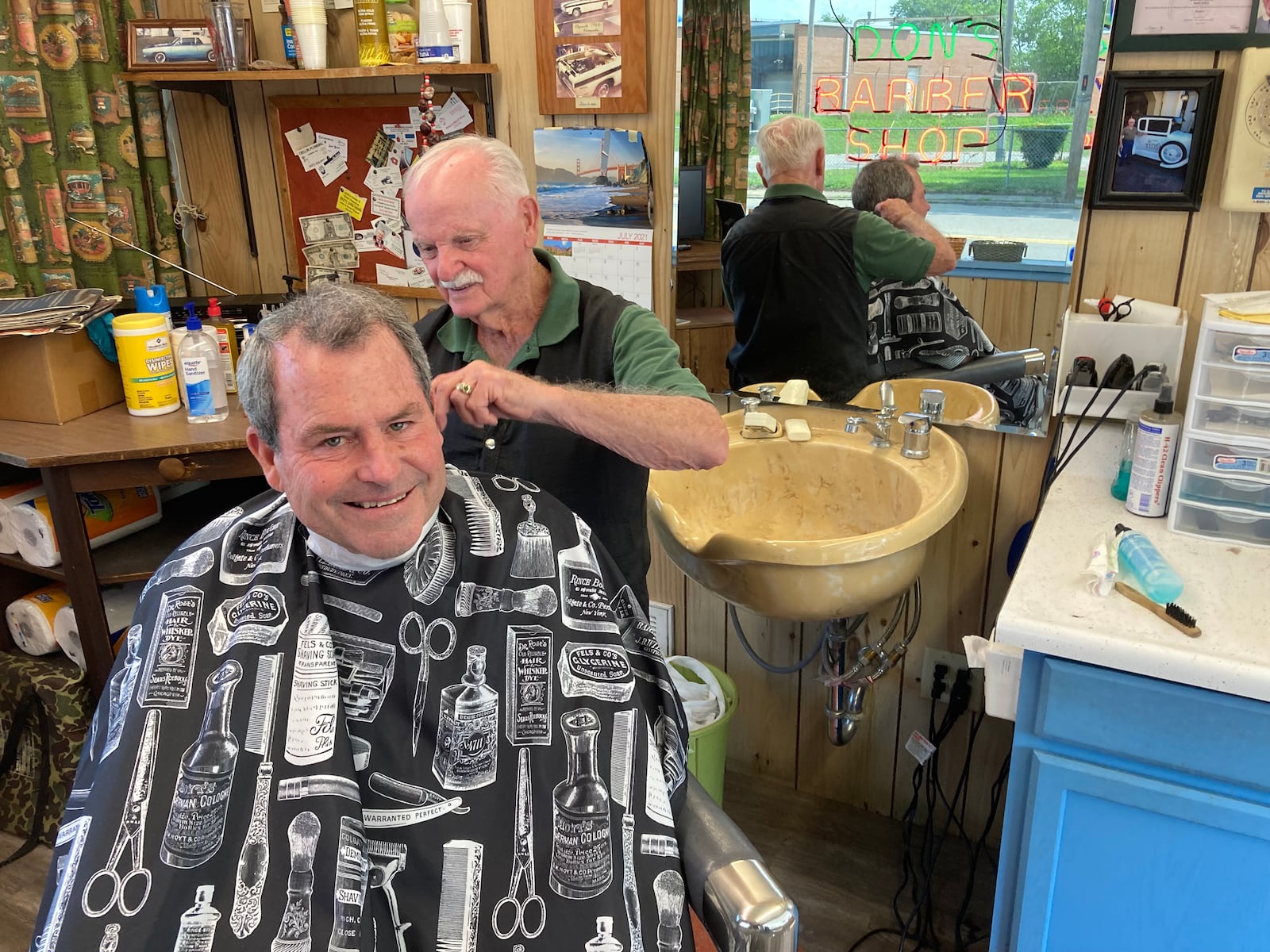 Don Maine trims up Bill Brougher’s hair in Maine’s barber shop for the last time. TOM STAFFORD/CONTRIBUTED