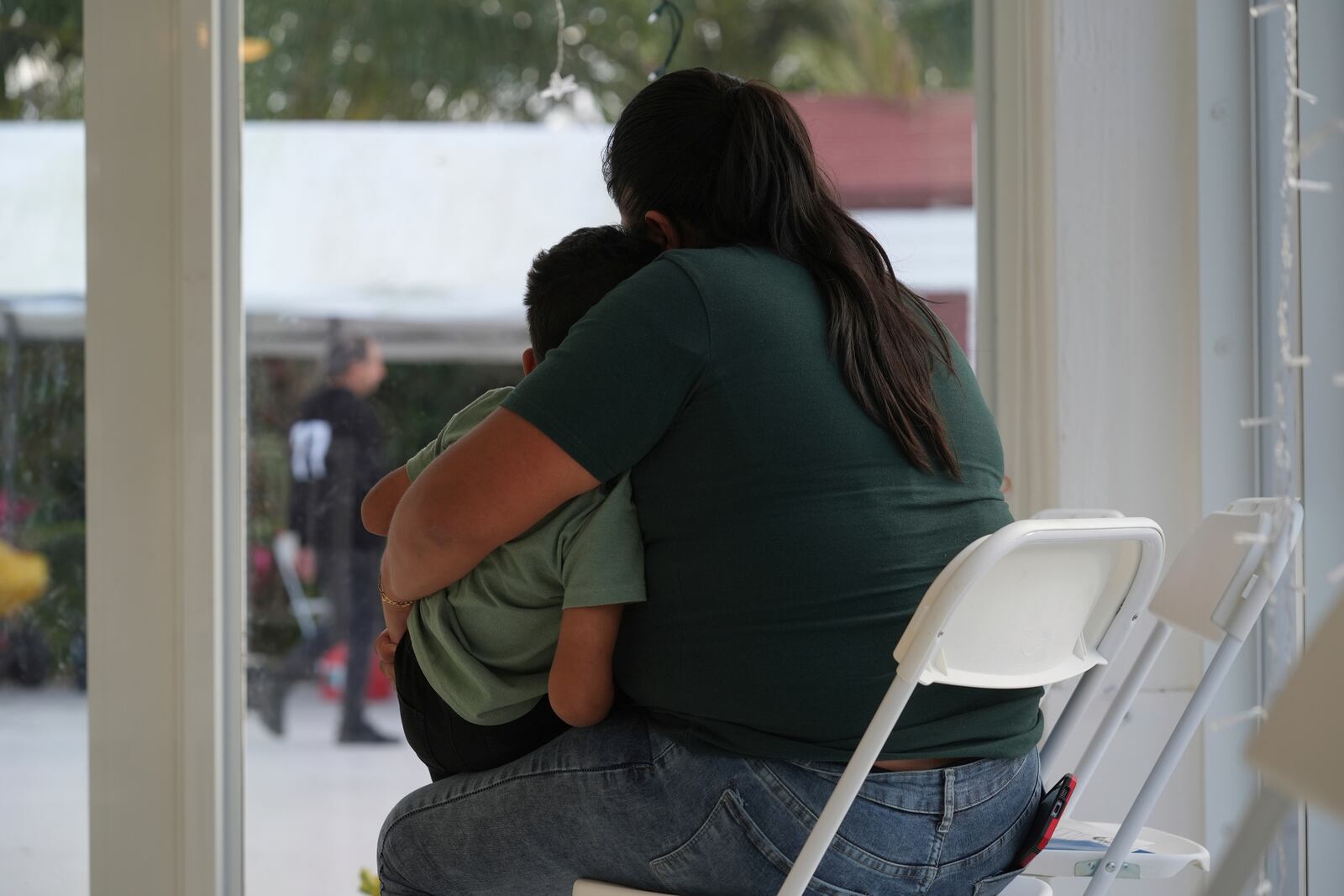 A mother embraces her young son after signing a document giving immigration advocate Nora Sandigo legal guardianship of him if she is detained or deported by immigration authorities, Sunday, Jan. 19, 2025, in Miami. (AP Photo/Marta Lavandier)