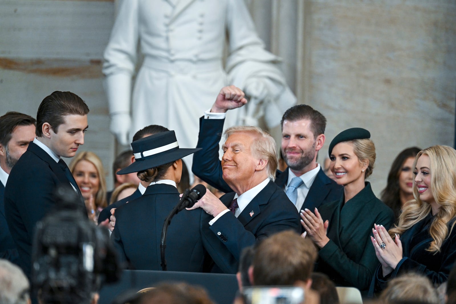 President Donald Trump, center, celebrates with Barron Trump, from left, Melania Trump, Eric Trump, Ivanka Trump and Tiffany Trump after being sworn in the 60th Presidential Inauguration in the Rotunda of the U.S. Capitol in Washington, Monday, Jan. 20, 2025. (Kenny Holston/The New York Times via AP, Pool)