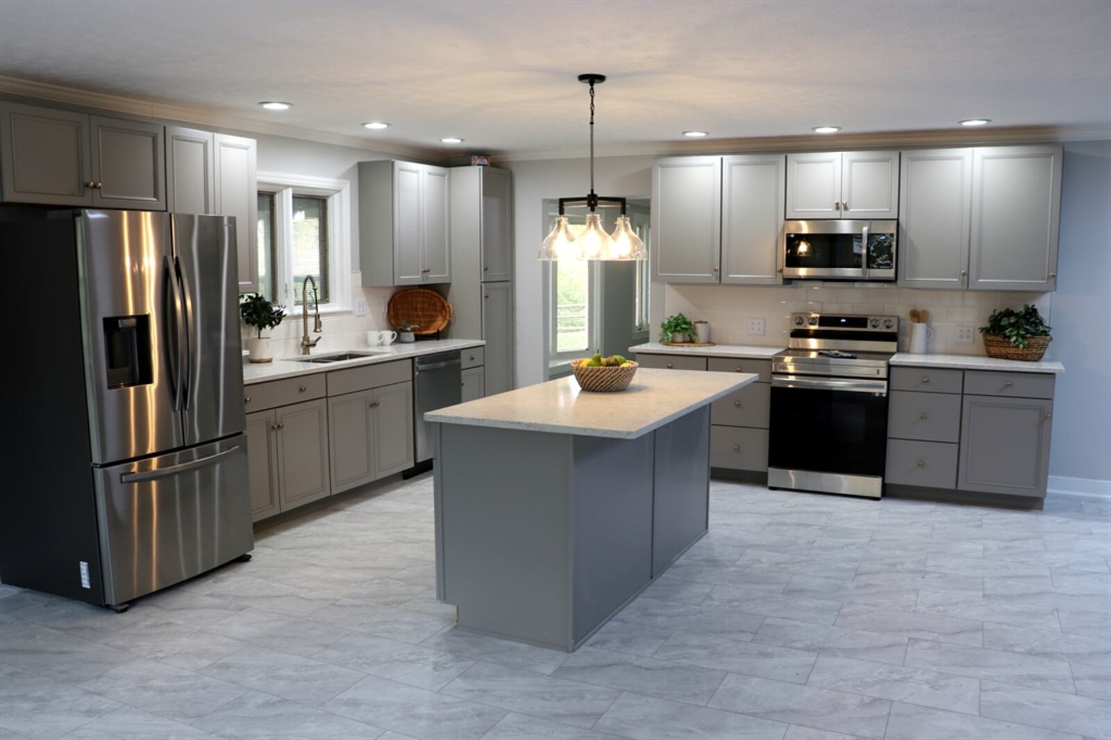 The kitchen has two walls of white cabinetry with subway tile-accented walls. 