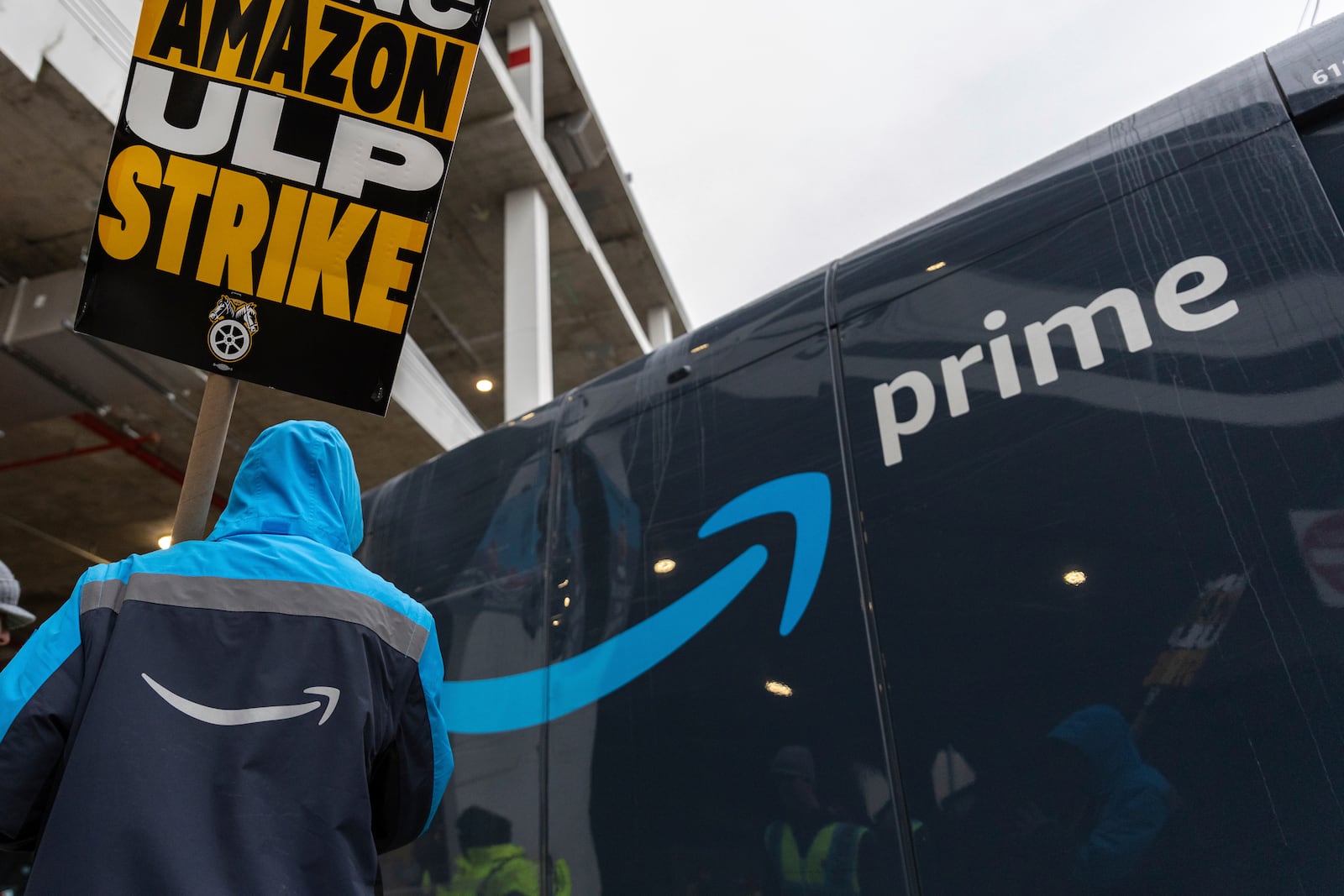 Amazon workers and members of the International Brotherhood of Teamsters picket in front of the Amazon fulfillment center in the Queens borough of New York, Friday, Dec. 20, 2024. (AP Photo/Stefan Jeremiah)