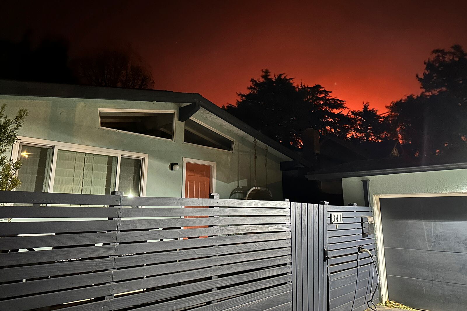 The home of Ryan Pearson, a Los Angeles-based entertainment video editor for The Associated Press, in Altadena, Calif., is seen as he and his family evacuate due to the Eaton Fire, Tuesday, Jan. 7, 2025. (AP Photo/Ryan Pearson)