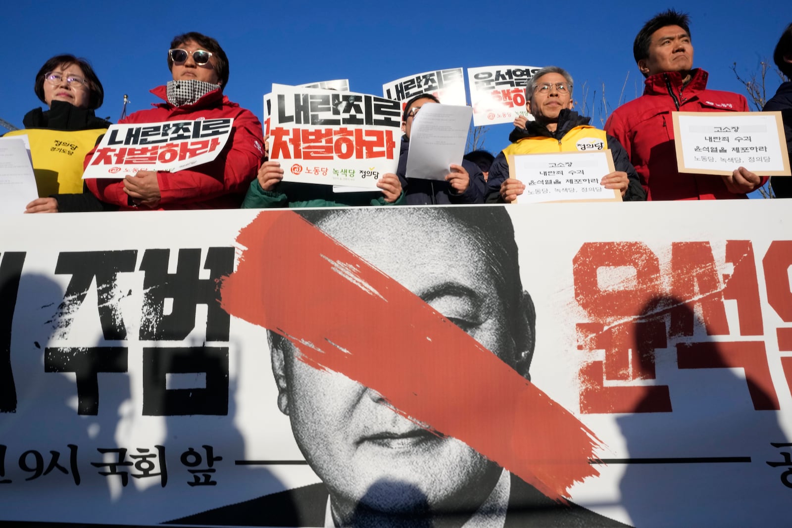 Protesters stage a rally to demand South Korean President Yoon Suk Yeol to step down in front of the National Assembly in Seoul, South Korea, Wednesday, Dec. 4, 2024. The signs read "Punish." (AP Photo/Ahn Young-joon)