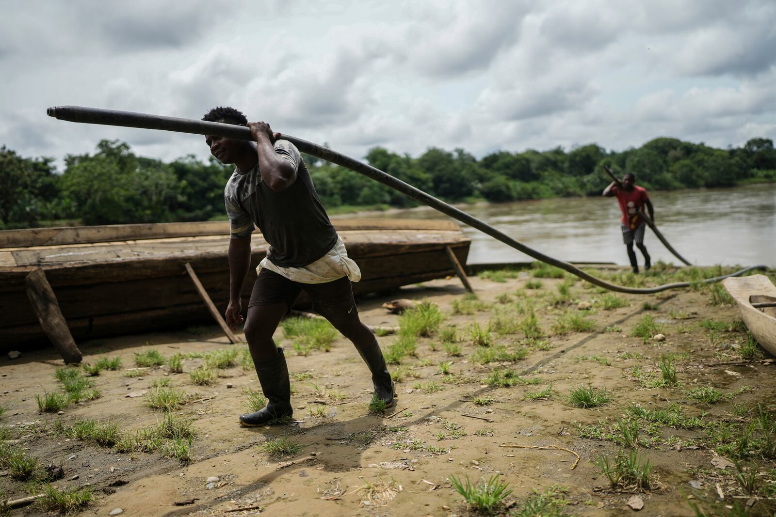 Men carry hoses to transport gasoline in El Arenal, Colombia, Thursday, Sept. 26, 2024. (AP Photo/Ivan Valencia)