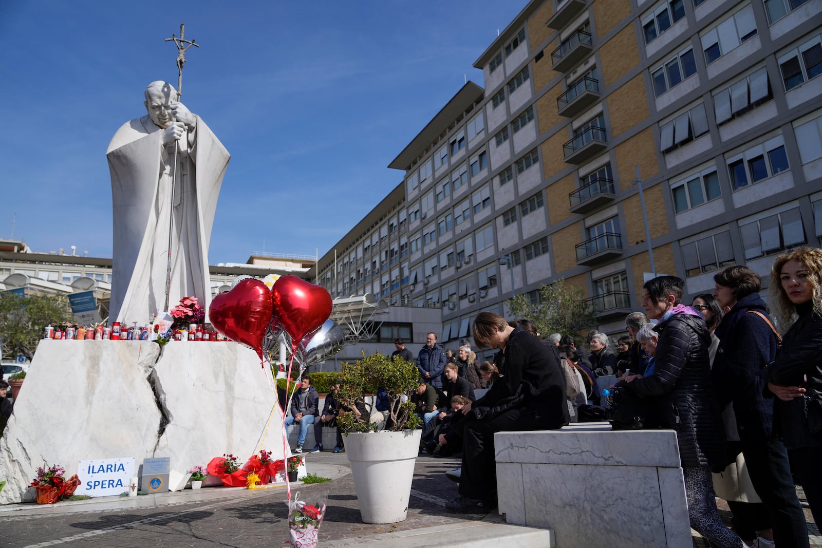 People pray outside the Agostino Gemelli Polyclinic in Rome, Sunday, Feb. 23, 2025, where Pope Francis is hospitalized since Feb. 14. (AP Photo/Gregorio Borgia)