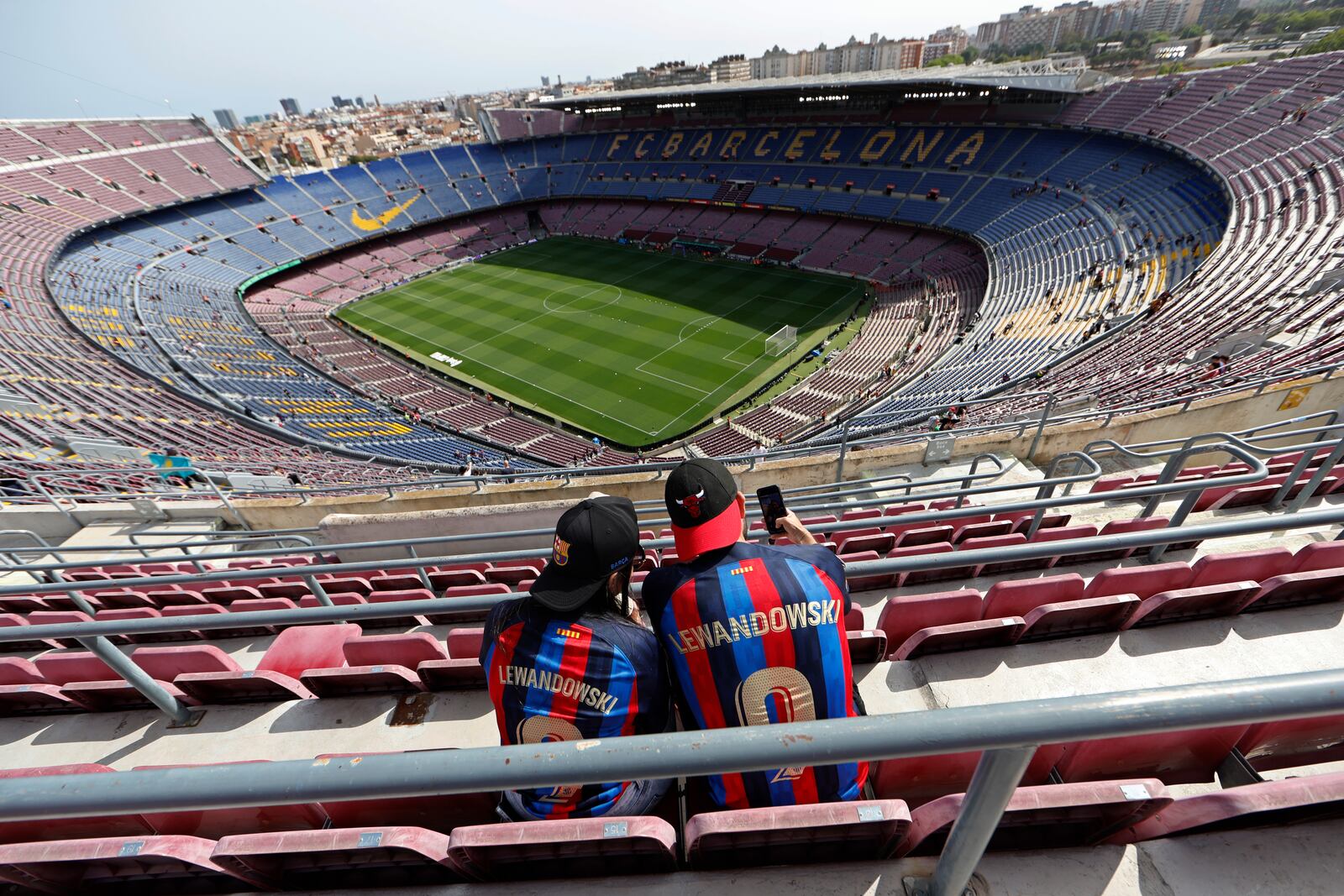 FILE - Two Barcelona fans wait for the start of a Spanish La Liga soccer match between Barcelona and Mallorca at the Camp Nou stadium in Barcelona, Spain, Sunday, May 28, 2023. (AP Photo/Joan Monfort, File)