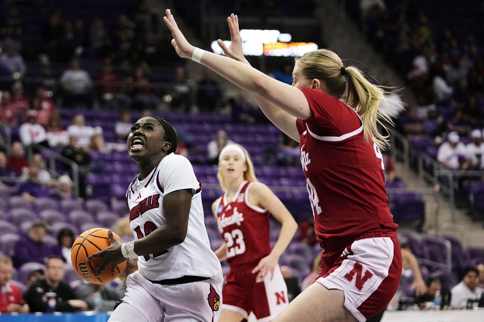 Louisville guard Ja'Leah Williams, left, drives to the basket as Nebraska's Petra Bozan, right, defends in the first half in the first round of the NCAA college basketball tournament in Fort Worth, Texas, Friday, March 21, 2025. (AP Photo/Tony Gutierrez)