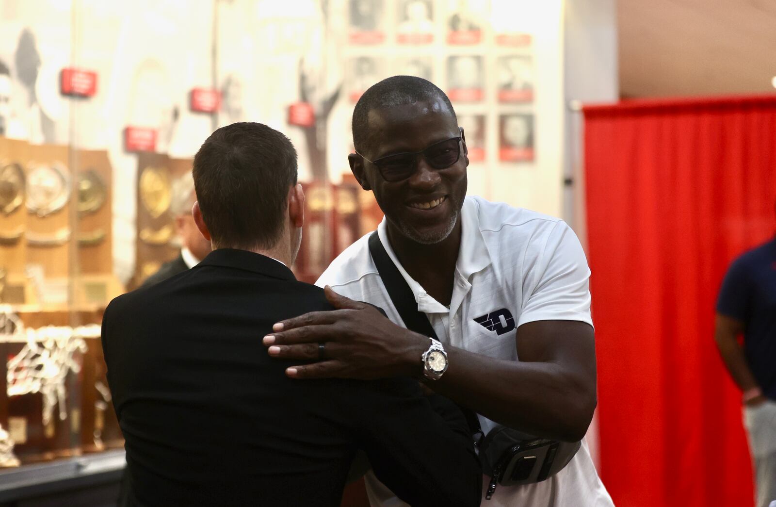 Darren Hertz, left, hugs Dayton head coach Anthony Grant at a press conference where Hertz was introduced as Wittenberg men's basketball coach on Tuesday, Sept. 3, 2024, in Springfield. David Jablonski/Staff