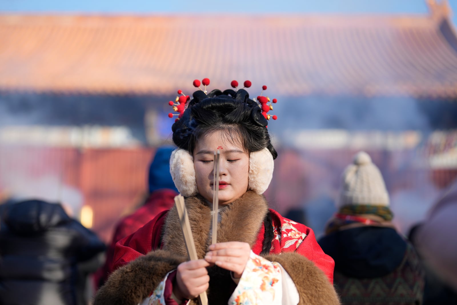 A woman in a traditional costume prays on the first day of the Chinese Lunar New Year at Lama Temple in Beijing on Wednesday, Jan. 29, 2025. (AP Photo/Aaron Favila)