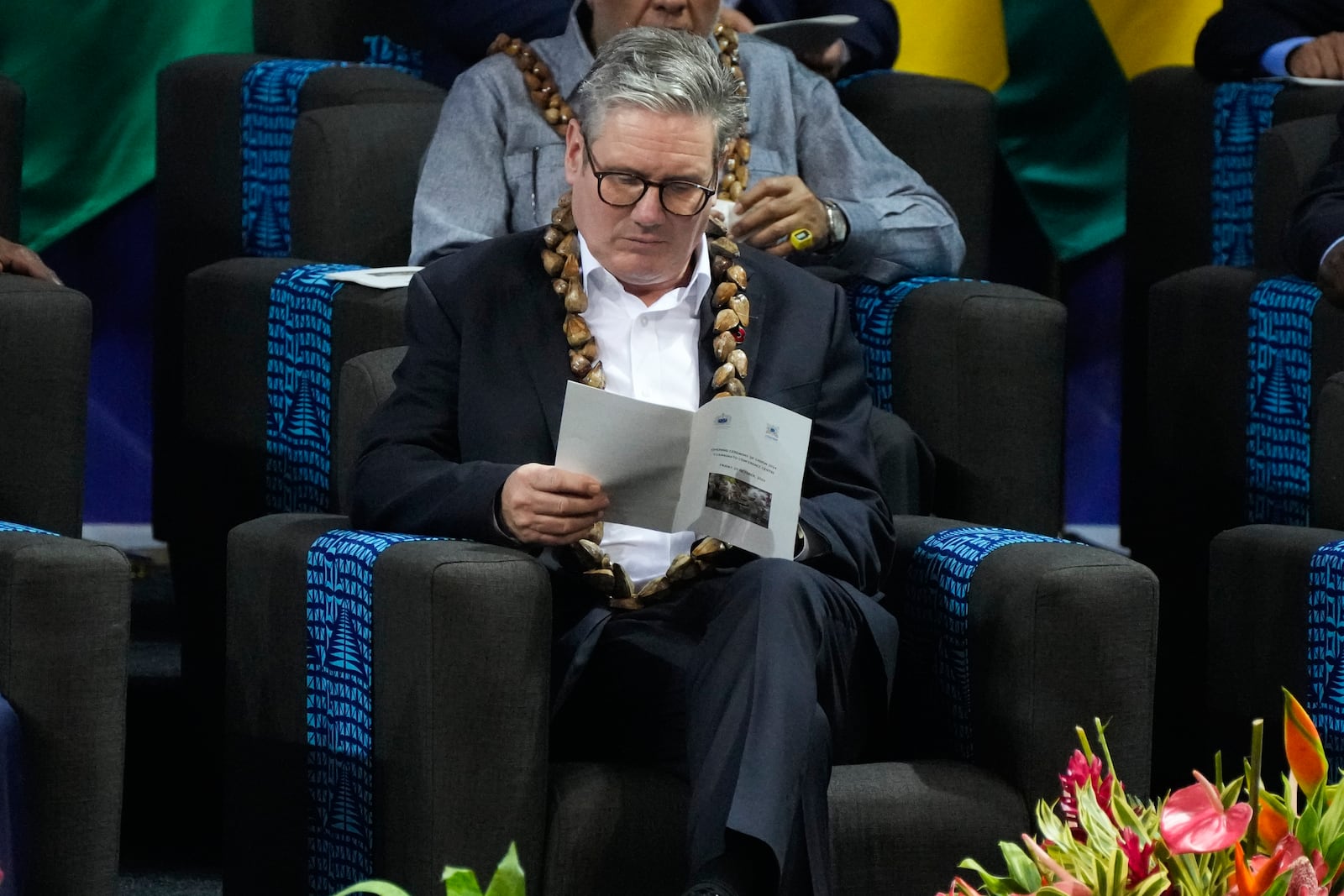 British Prime Minister Keir Starker reads a programme during the opening ceremony of the Commonwealth Heads of Government meeting in Apia, Samoa, Friday, Oct. 25, 2024. (AP Photo/Rick Rycroft/Pool)