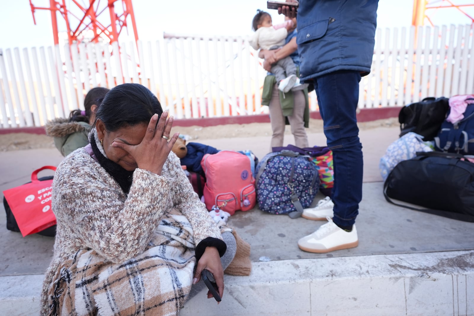 Maria Mercado, who is from Columbia but arrived from Ecuador, gets emotional as she sees that her 1pm appointment was canceled on the U.S. Customs and Border Protection (CBP) One app, as she and her family wait at the border crossing in Tijuana, Mexico on Monday, Jan. 20. 2025. (AP Photo/Gregory Bull)