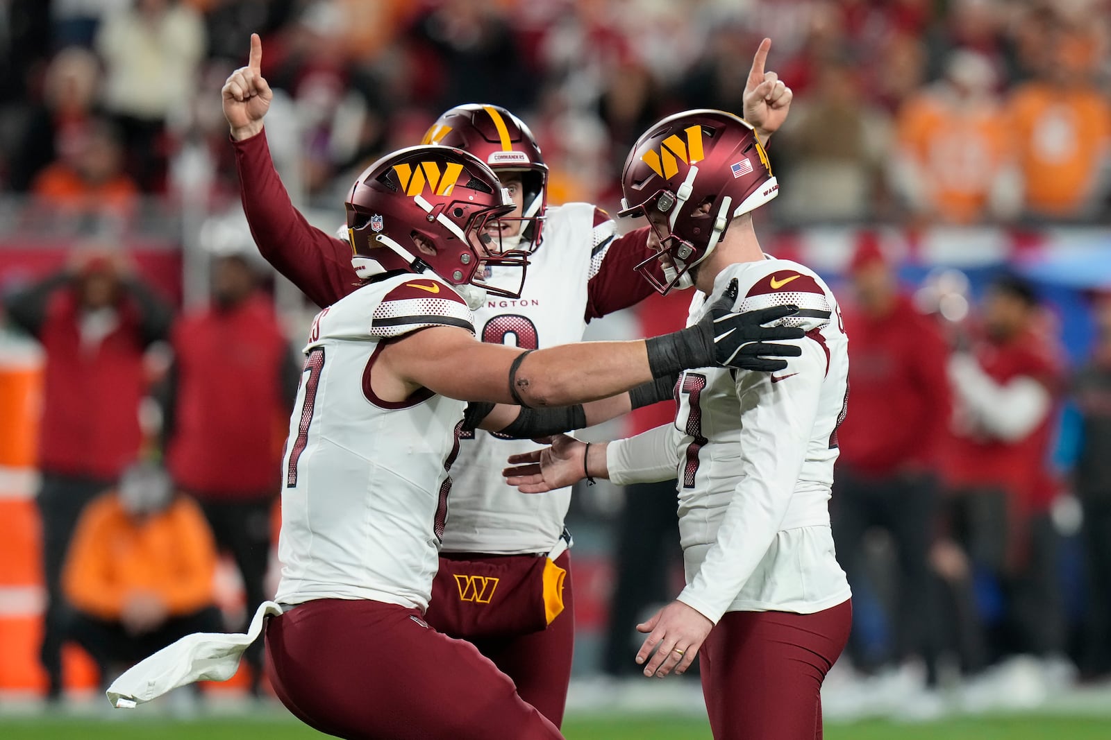 Washington Commanders place kicker Zane Gonzalez, right, is congratulated by teammates after kicking the game winning field goal against the Tampa Bay Buccaneers during the second half of an NFL wild-card playoff football game in Tampa, Fla., Sunday, Jan. 12, 2025. (AP Photo/Chris O'Meara)