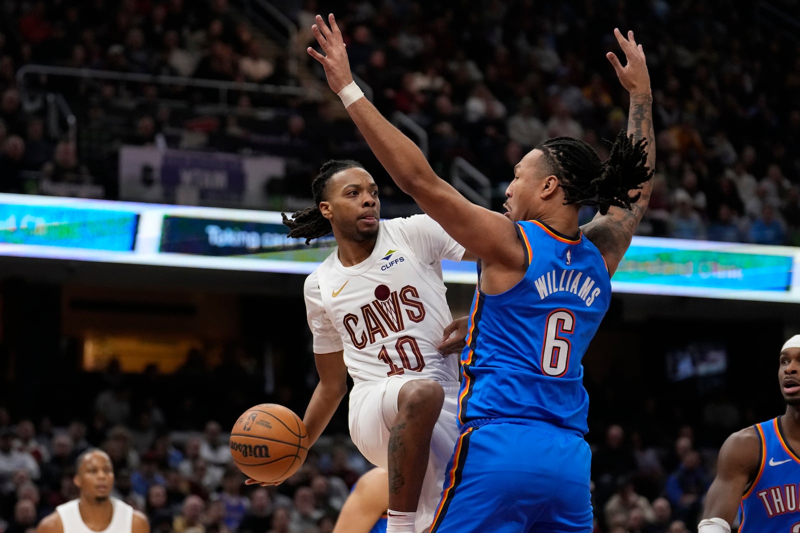 Cleveland Cavaliers guard Darius Garland (10) passes around Oklahoma City Thunder forward Jaylin Williams (6) in the first half of an NBA basketball game, Wednesday, Jan. 8, 2025, in Cleveland. (AP Photo/Sue Ogrocki)