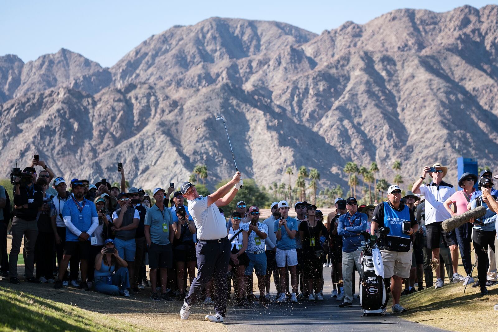 Fans watch as Sepp Straka hits toward the fifth fairway at the Pete Dye Stadium Course during the final round of the American Express golf tournament in La Quinta, Calif., Sunday, Jan. 19, 2025. (AP Photo/William Liang)