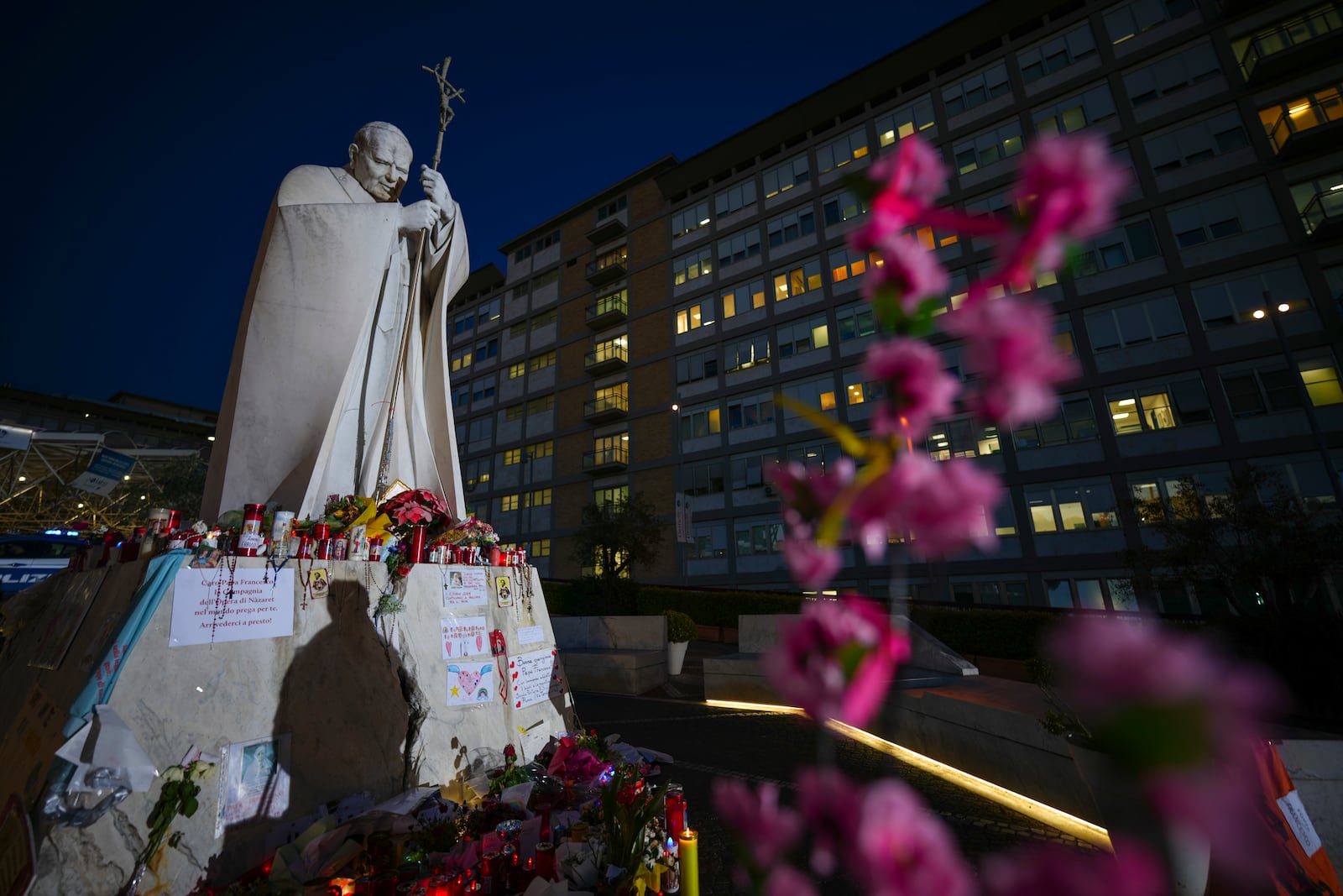 A woman casts her shadow as she prays for Pope Francis in front of the Agostino Gemelli Polyclinic, in Rome, Wednesday, March 19, 2025, where the Pontiff is hospitalized since Friday, Feb. 14. (AP Photo/Andrew Medichini)