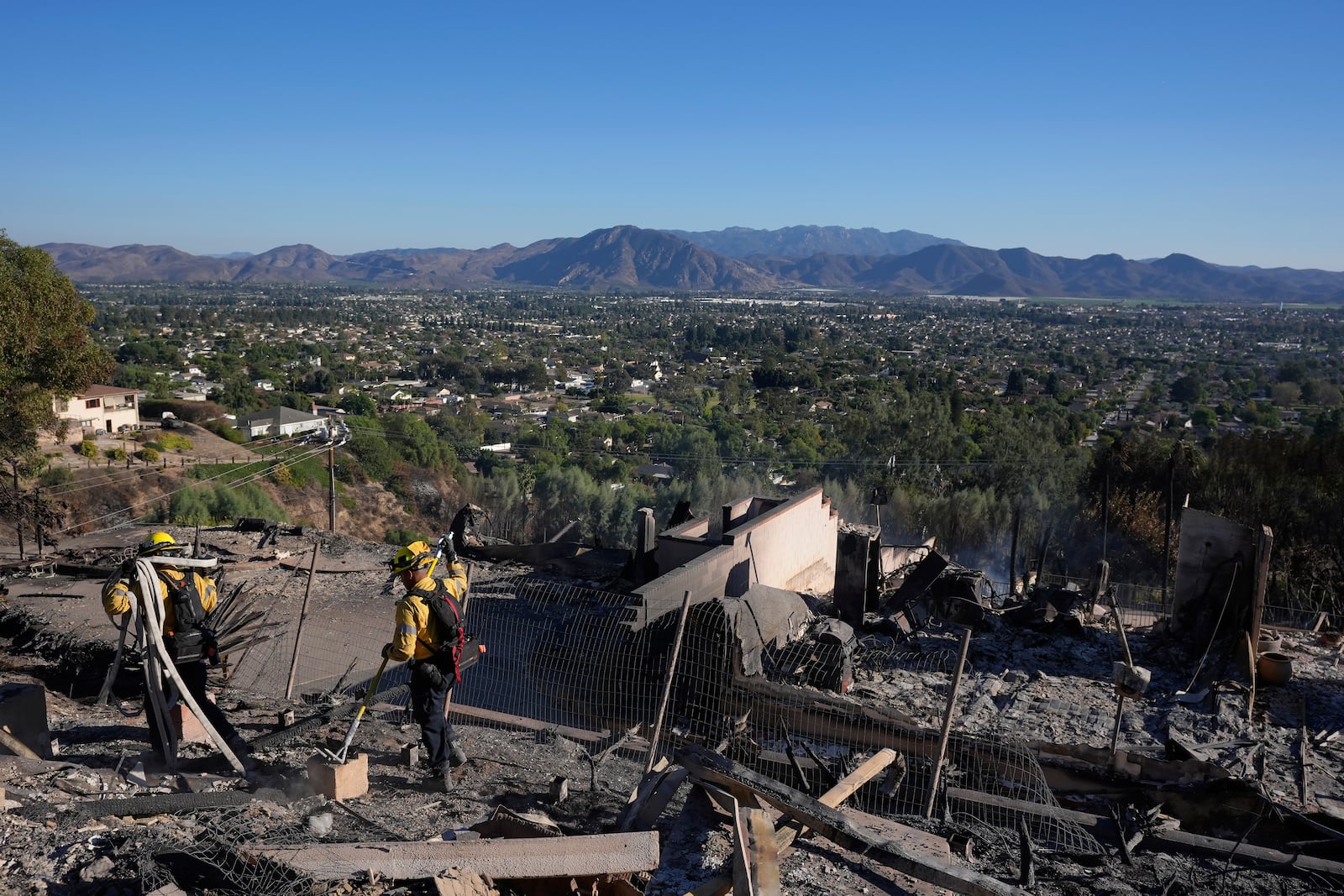 Los Angeles Fire Department firefighters work at a home destroyed by the Mountain Fire in Camarillo, Calif., Friday, Nov. 8, 2024. (AP Photo/Jae C. Hong)