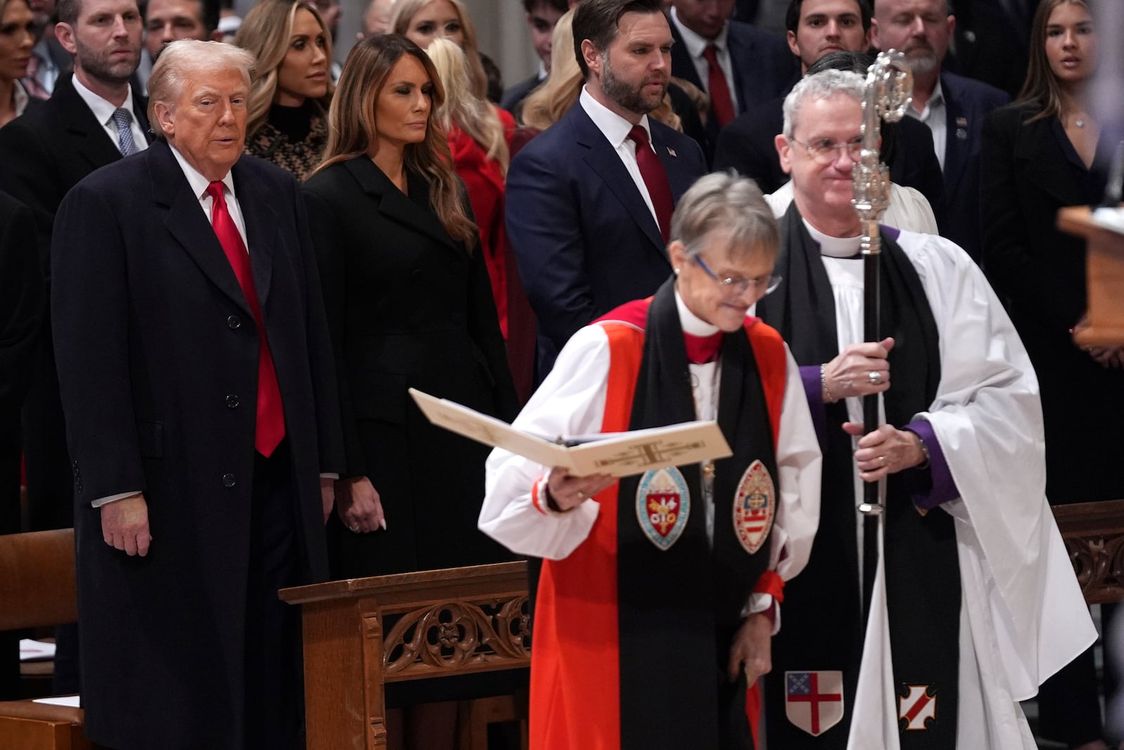 President Donald Trump, left, watches as Rev. Mariann Budde, second right, arrives at the national prayer service at the Washington National Cathedral, Tuesday, Jan. 21, 2025, in Washington. (AP Photo/Evan Vucci)