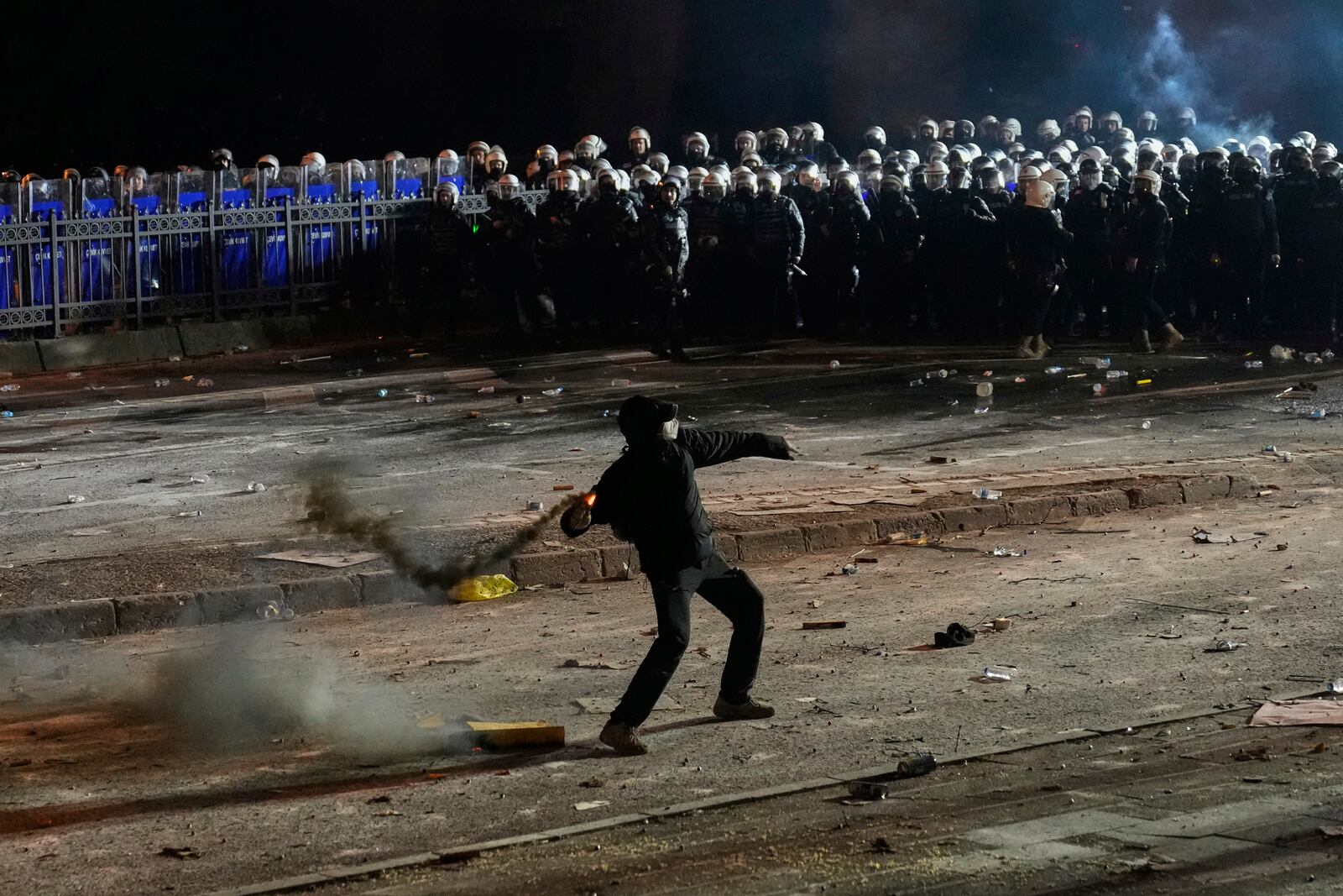 A protester throws a firework during a protest against the arrest of Istanbul's Mayor Ekrem Imamoglu, in Istanbul, Turkey, Saturday, March 22, 2025. (AP Photo/Khalil Hamra)