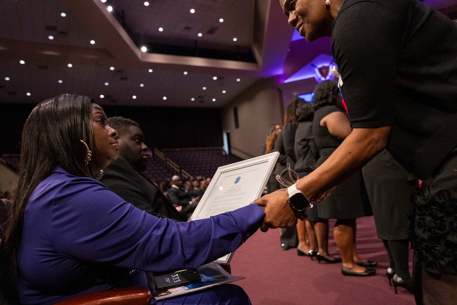 Diamond, daughter of Angie Stone, receives a plaque in honor of her mother at a memorial service, Friday, March 14, 2025, in Austell. Ga. (AP Photo/Olivia Bowdoin)