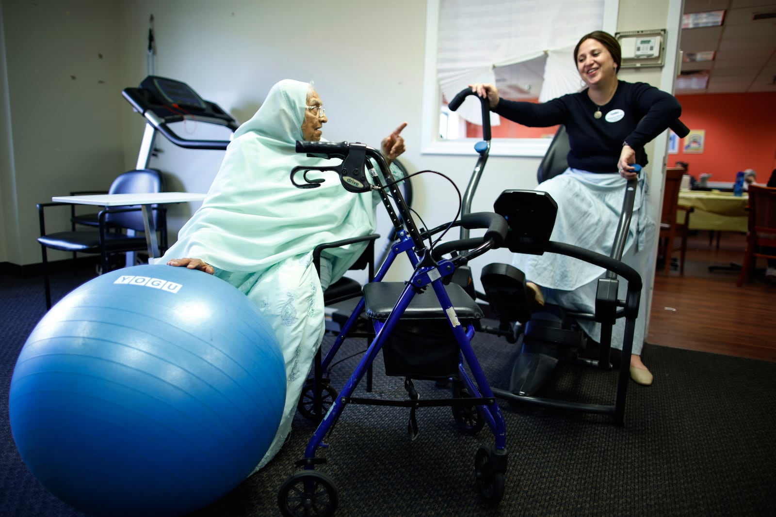 Bibi, 84, talks to Hadassah Wilhelm, director of community relations, during a physical therapy session at Sunshine Adult Day Center in Bergenfield, N.J., Monday, Aug. 26, 2024. (AP Photo/Kena Betancur)