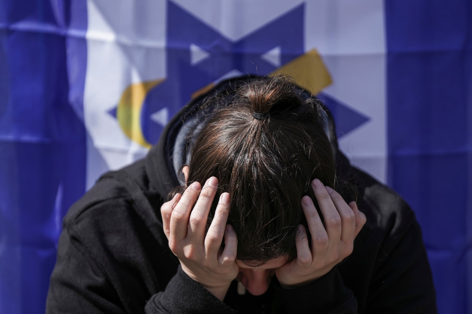 A woman reacts at the so-called 'Hostages Square' in Tel Aviv, Israel, Thursday, Feb. 20, 2025, as the bodies of four Israeli hostages, including a mother and her two children, are handed over by Hamas to the Red Cross in Gaza. (AP Photo/Oded Balilty)