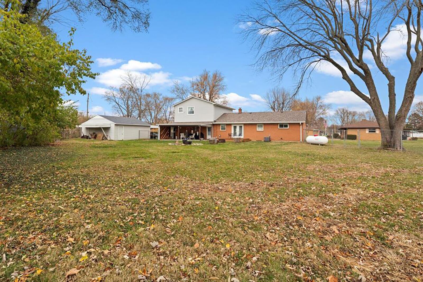 The rear of the home is fully fenced and features a wood deck with steps, a covered concrete patio and two-car detached garage.