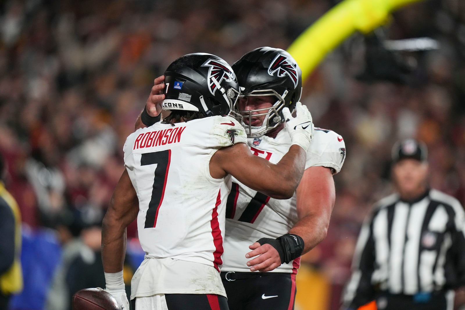 Atlanta Falcons running back Bijan Robinson (7) celebrates his touchdown with Arnold Ebiketie (17) during the first half of an NFL football game against the Washington Commanders, Sunday, Dec. 29, 2024, in Landover. (AP Photo/Stephanie Scarbrough)