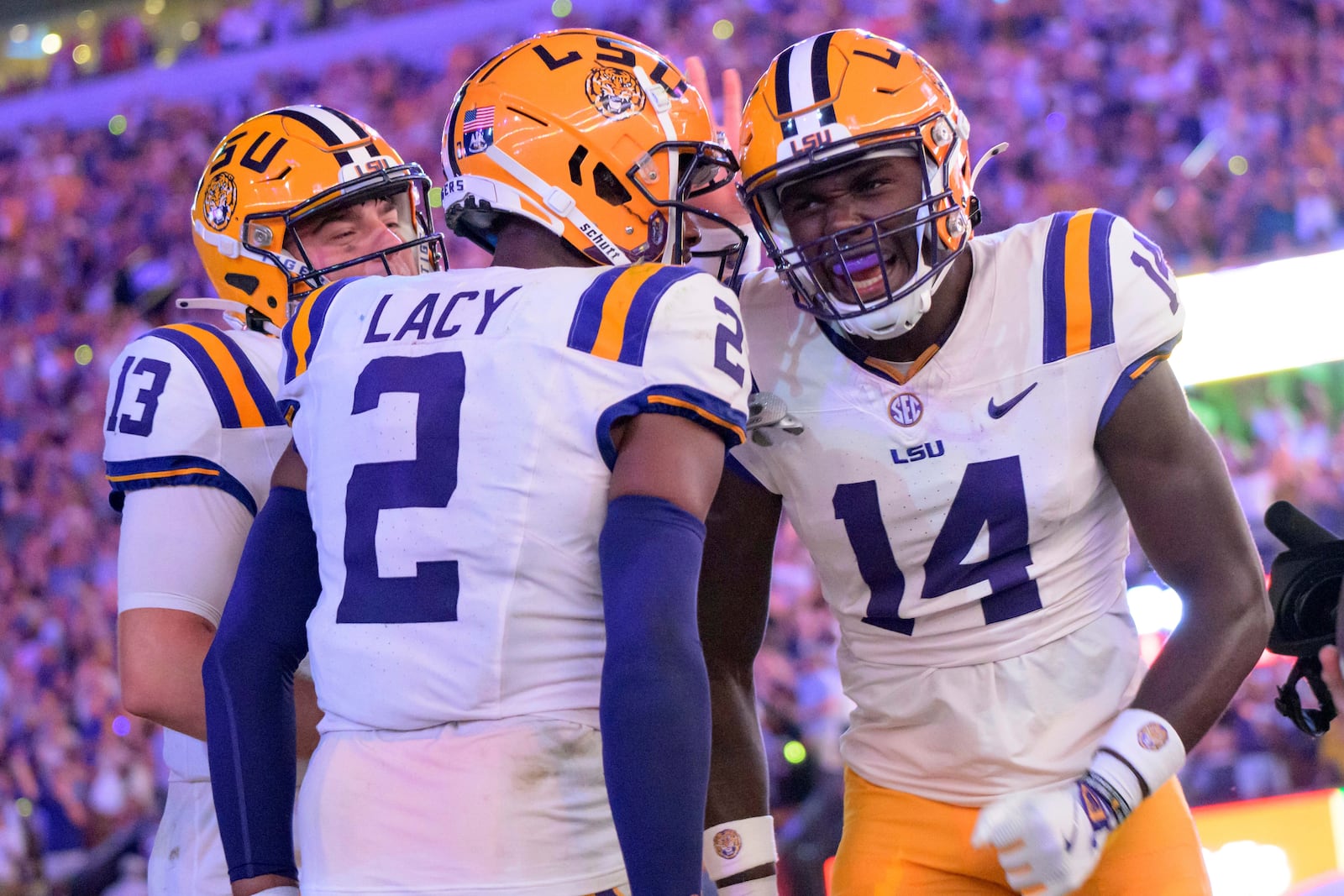 LSU tight end Trey'Dez Green (14) celebrates a touchdown with wide receiver Kyren Lacy (2) and LSU quarterback Garrett Nussmeier (13) during the first half of an NCAA college football game against Mississippi in Baton Rouge, La., Saturday, Oct. 12, 2024. (AP Photo/Matthew Hinton)