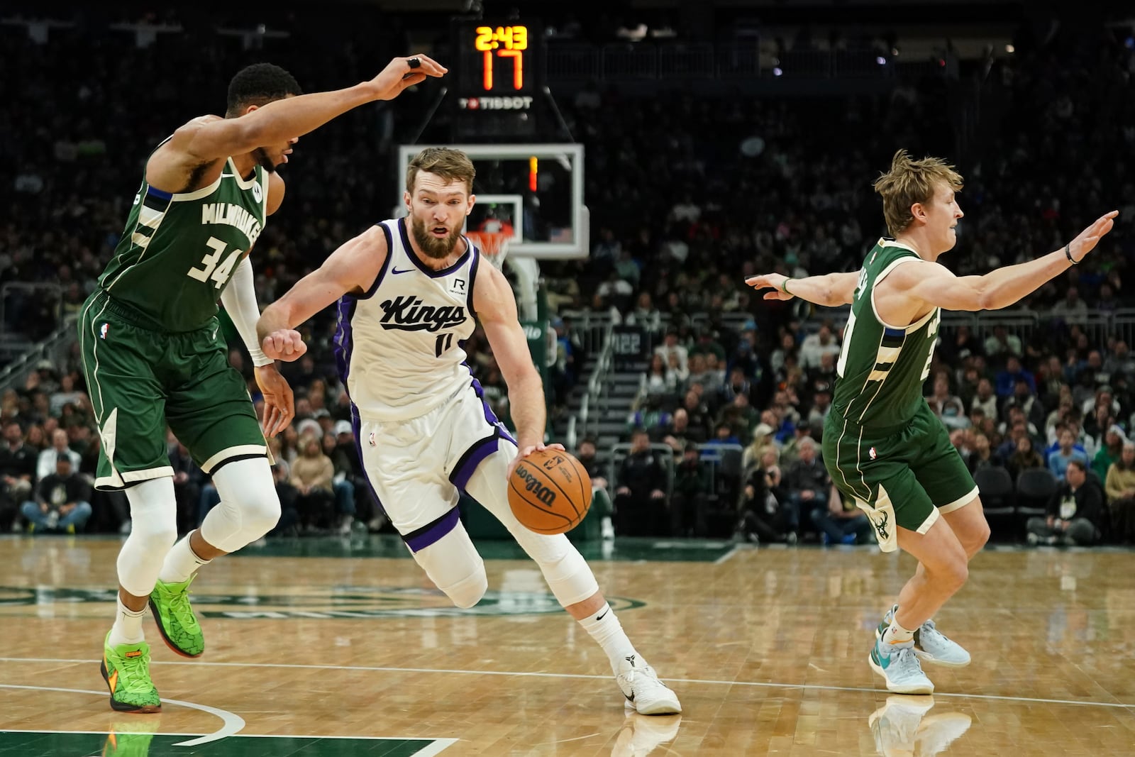 Sacramento Kings' Domantas Sabonis (11) drives to the basket against Milwaukee Bucks' Giannis Antetokounmpo (34) during the first half of an NBA basketball game Tuesday, Jan. 14, 2025, in Milwaukee. (AP Photo/Aaron Gash)