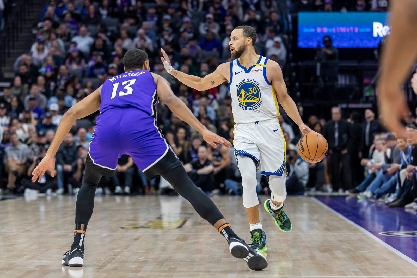 Golden State Warriors guard Stephen Curry (30) dribbles upcourt with Sacramento Kings forward Keegan Murray (13) on defense during the second half of an NBA basketball game Wednesday, Jan. 22, 2025, in Sacramento, Calif. (AP Photo/Sara Nevis)